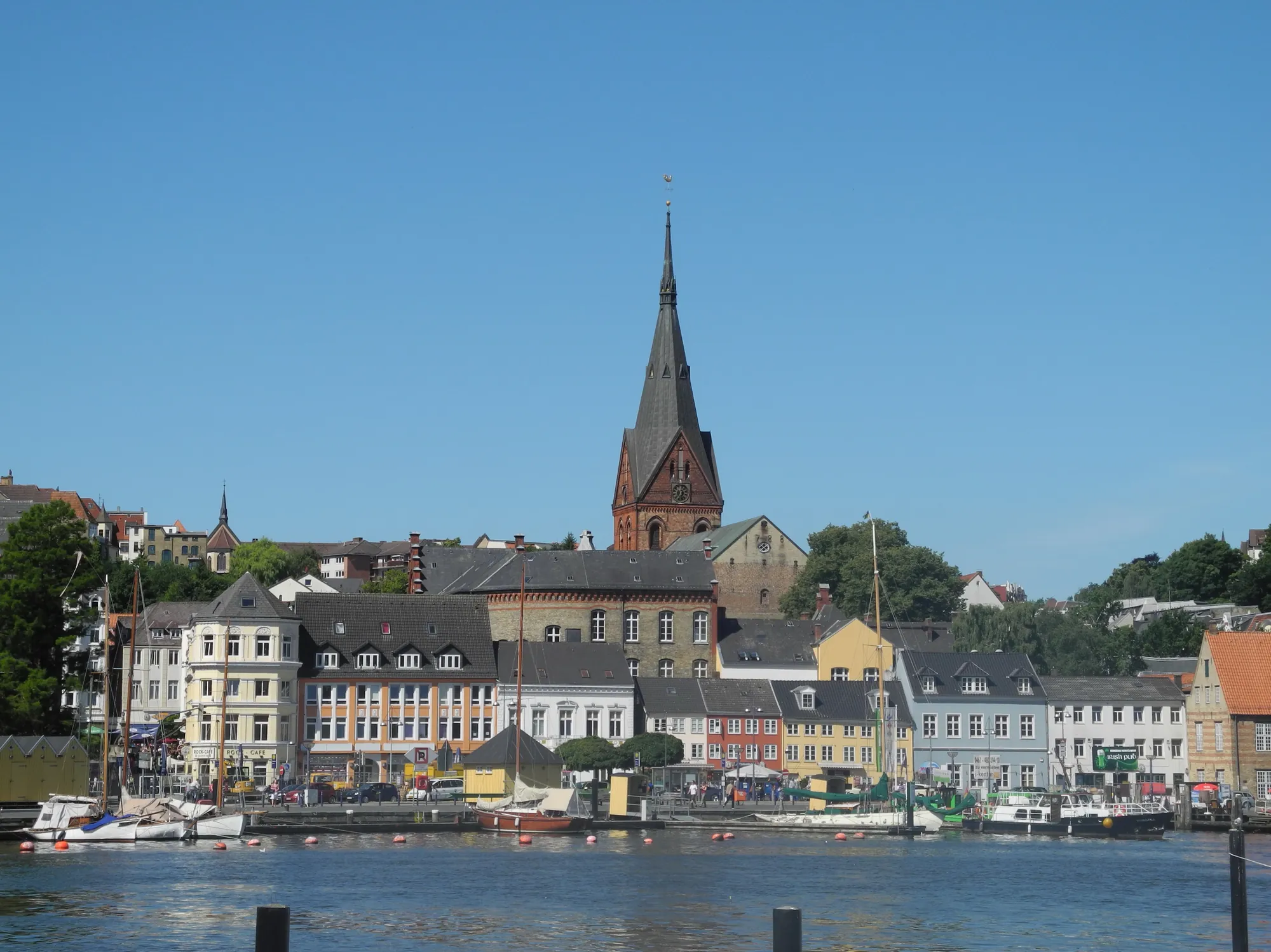 Hafen mit Kneipen und Restaurants neben dem Kompagnietor und der Marienkirche im Hintergrund in Flensburg