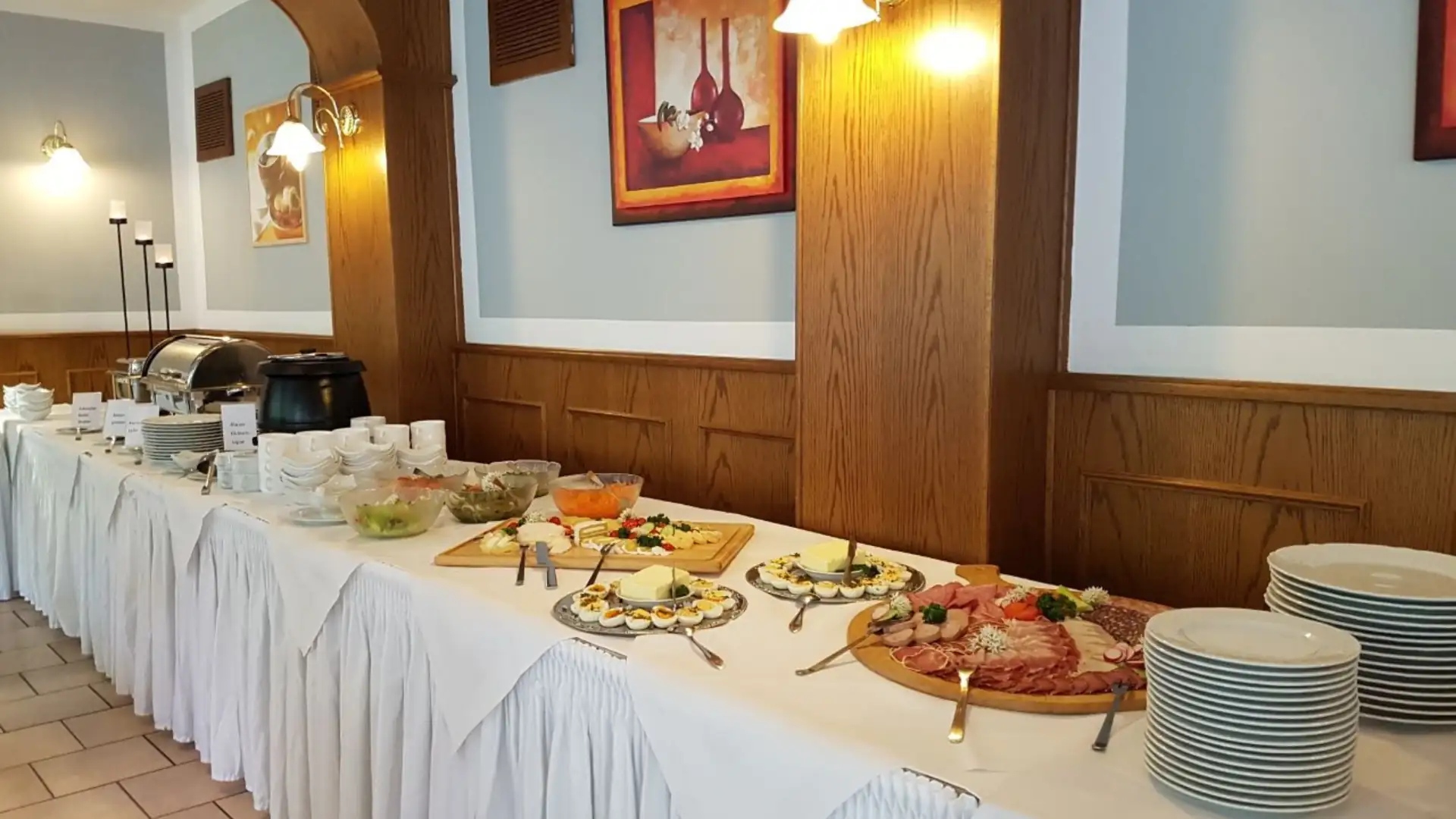 Buffet im Ferienhotel Forelle mit Tellern, Schalen, Aufschnitt, Salaten und warmen Speisen in einem Restaurant mit Holzvertäfelung