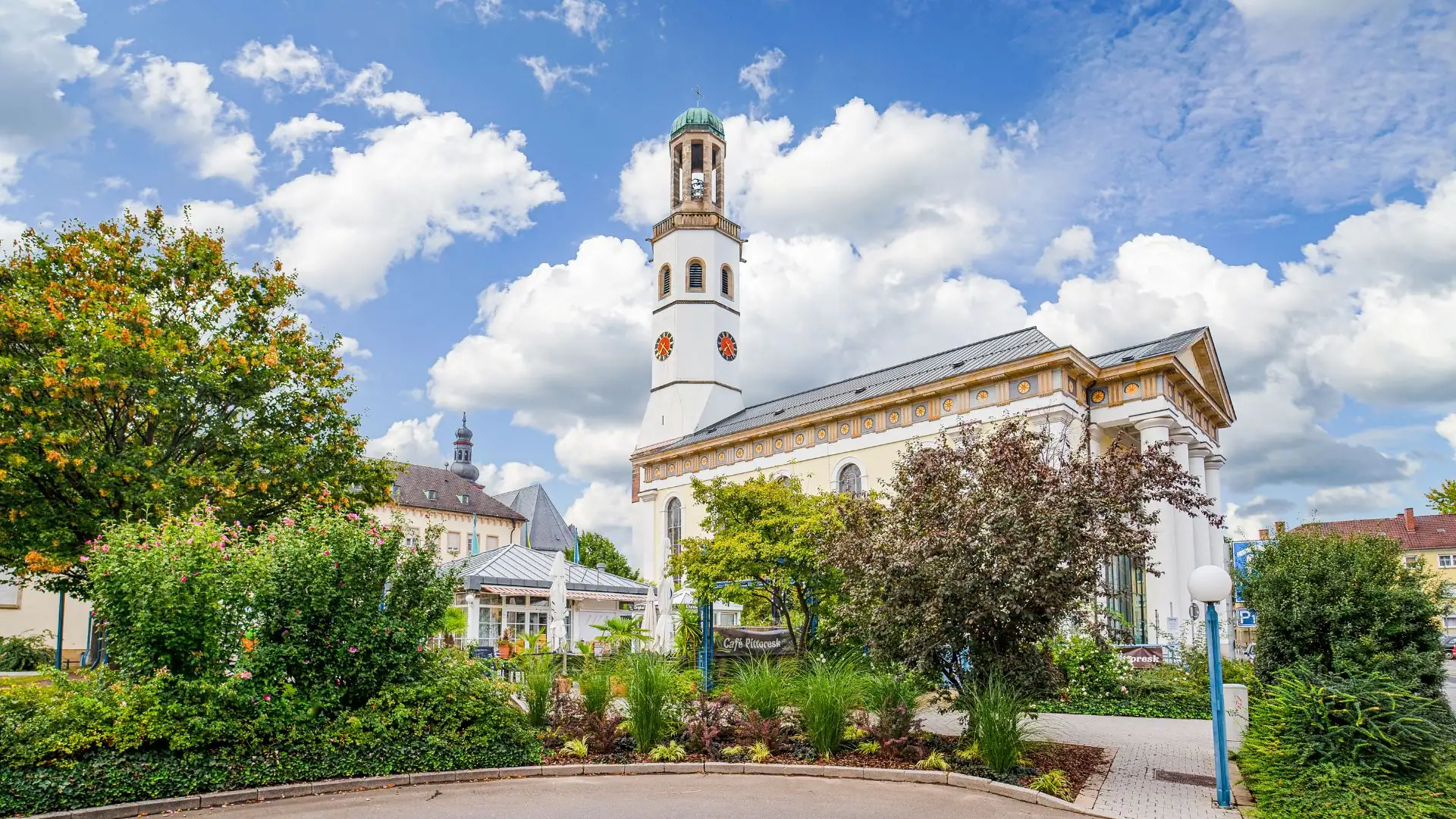 Eine malerische Kirche umgeben von grüner Landschaft und blauen Himmel.