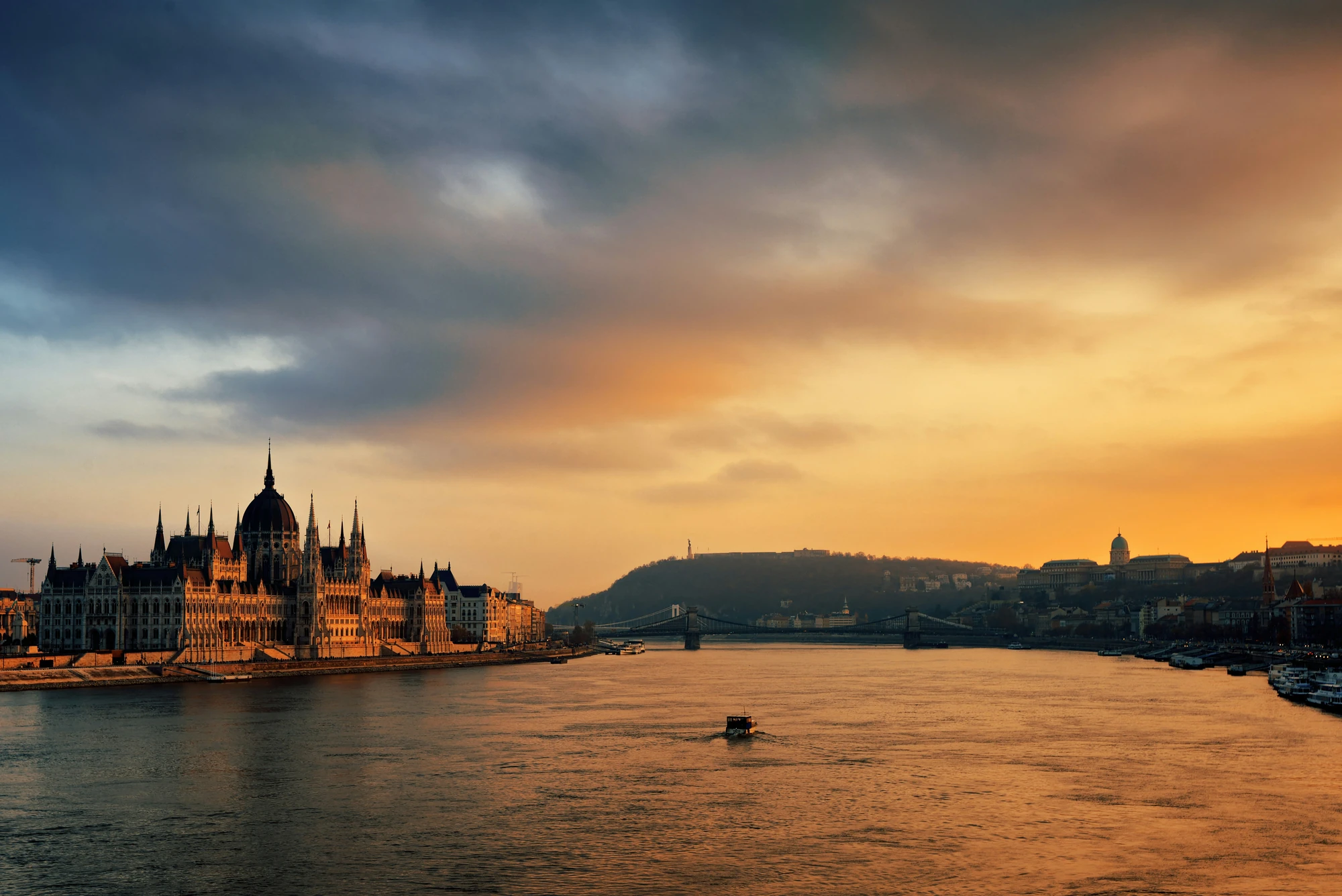Blick auf das ungarische Parlament am Ufer der Donau bei Sonnenuntergang in Budapest