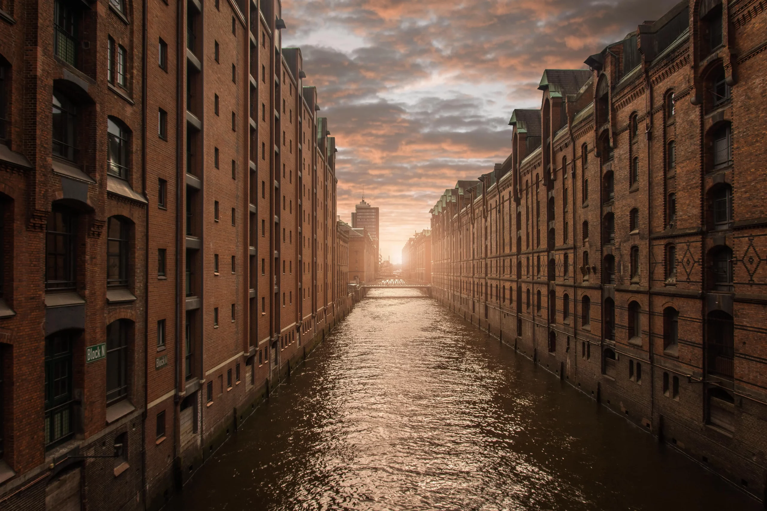 Blick in den Sonnenuntergang zwischen den charakteristischen neugotischen Backsteinarchitektur der Speicherstadt