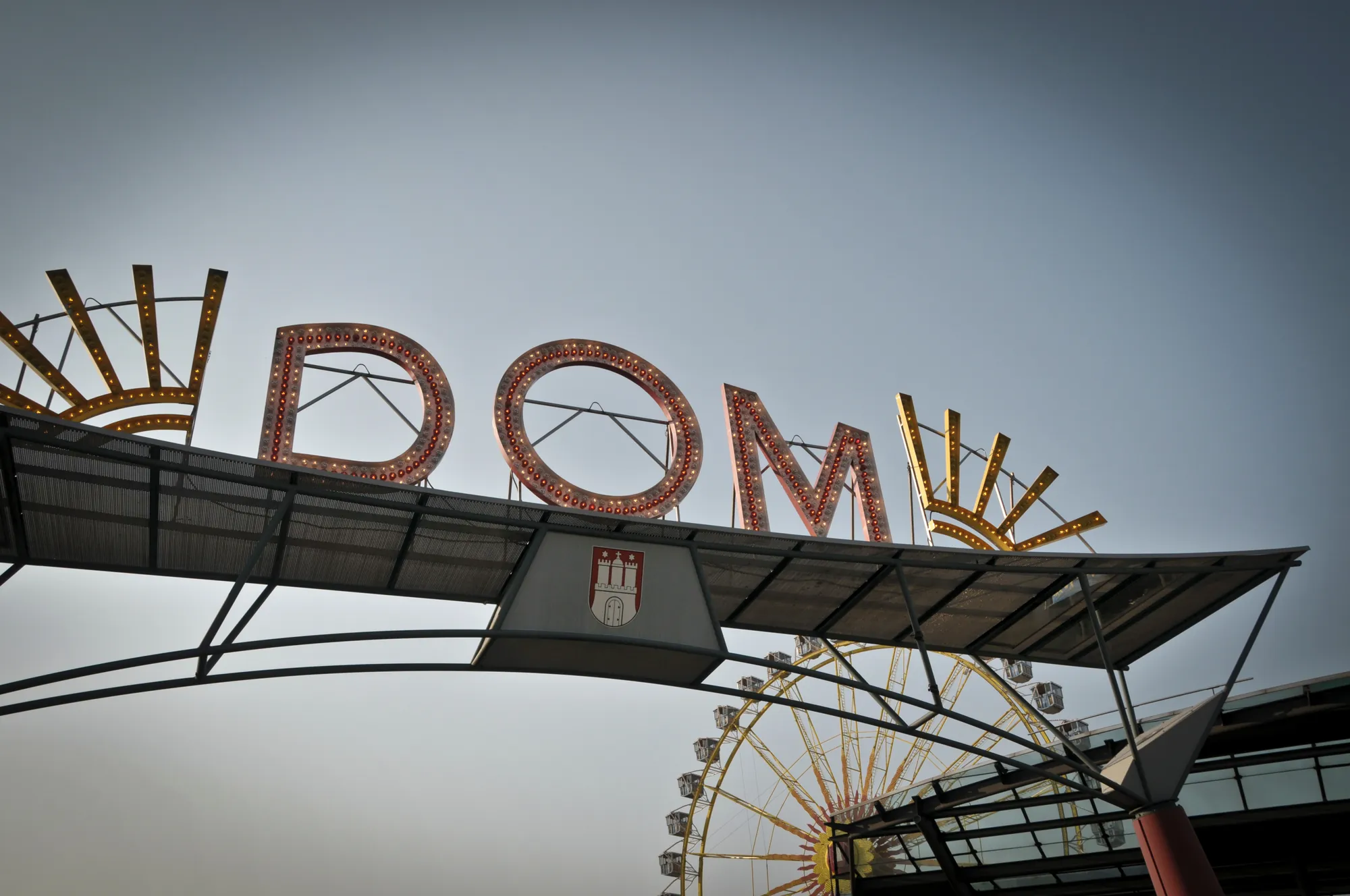 Hamburger Dom (Schriftzug Dom) mit Riesenrad im Hintergrund