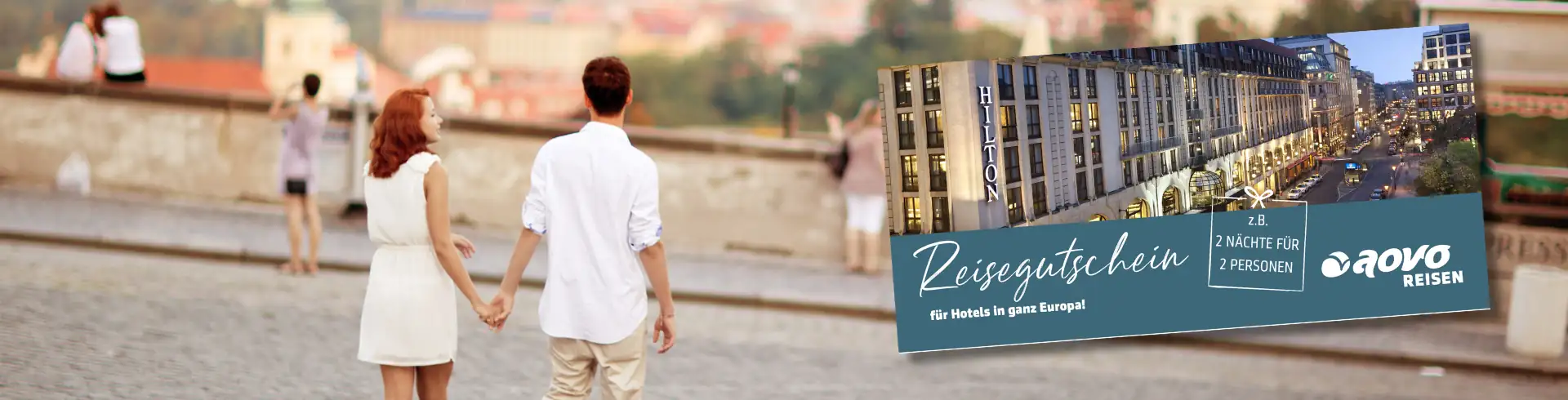 Paar hält Händchen in einer Altstadt, daneben Reisegutschein von aovo Reisen für 2 Nächte in Hilton Hotels in Europa