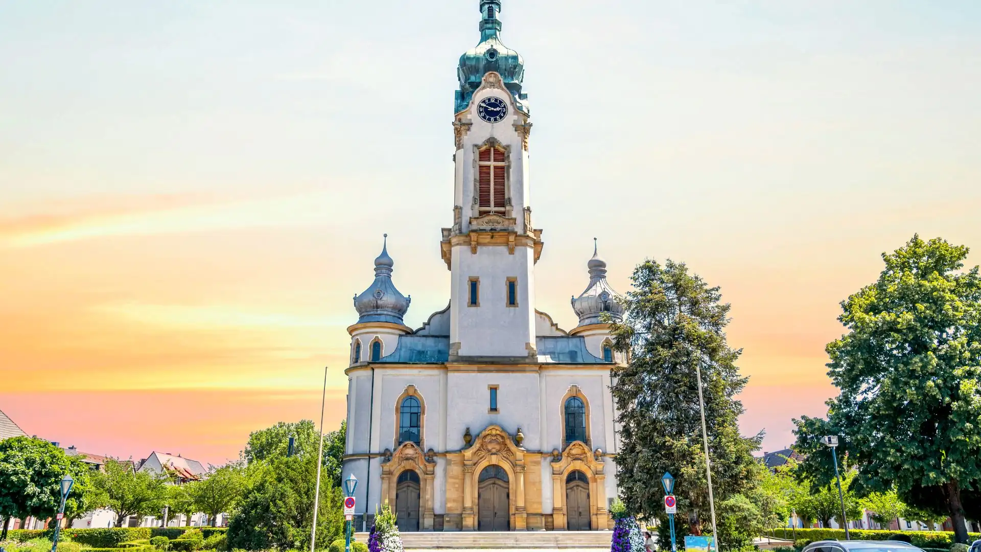 Historische Kirche mit Uhrturm bei Sonnenuntergang.