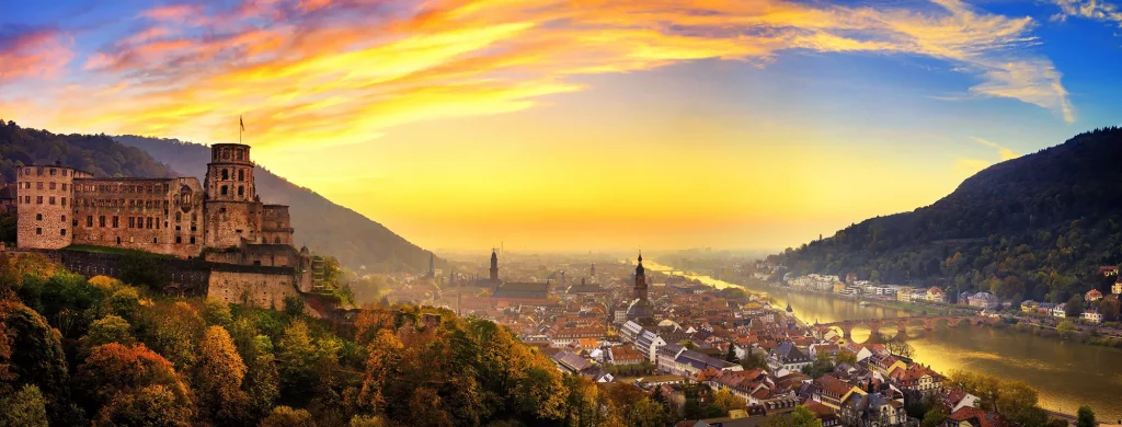 Panoramablick auf Schloss und Neckar bei Sonnenuntergang bei einer Reise mit Hotels in Heidelberg