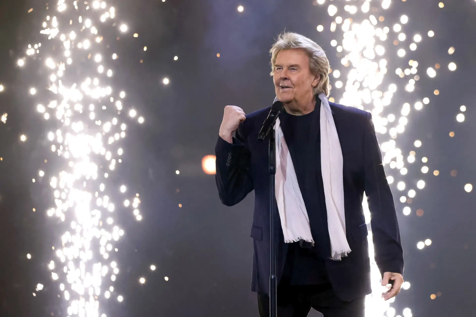 Howard Carpendale mit gereckter Faust und Funkenfontänen im Hintergrund während Liveauftritt 2024 (Livefoto)
