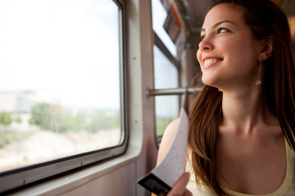 Glückliche Frau auf ihrer Bahnreise, schaut nach draußen