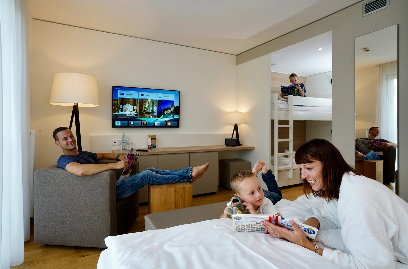 Ein modernes Familienzimmer im Wonnemar Resort Wismar, ideal für gemeinsame Momente mit der Familie, ausgestattet mit komfortablen Betten, Unterhaltungselektronik und einem gemütlichen Ambiente für Groß und Klein.