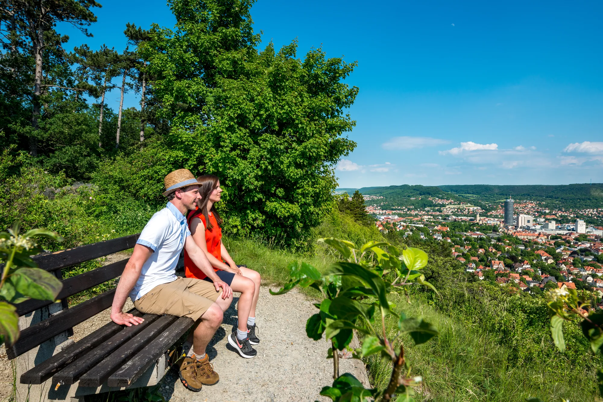 2 Wanderer auf einer sitzbank blicken auf Jena