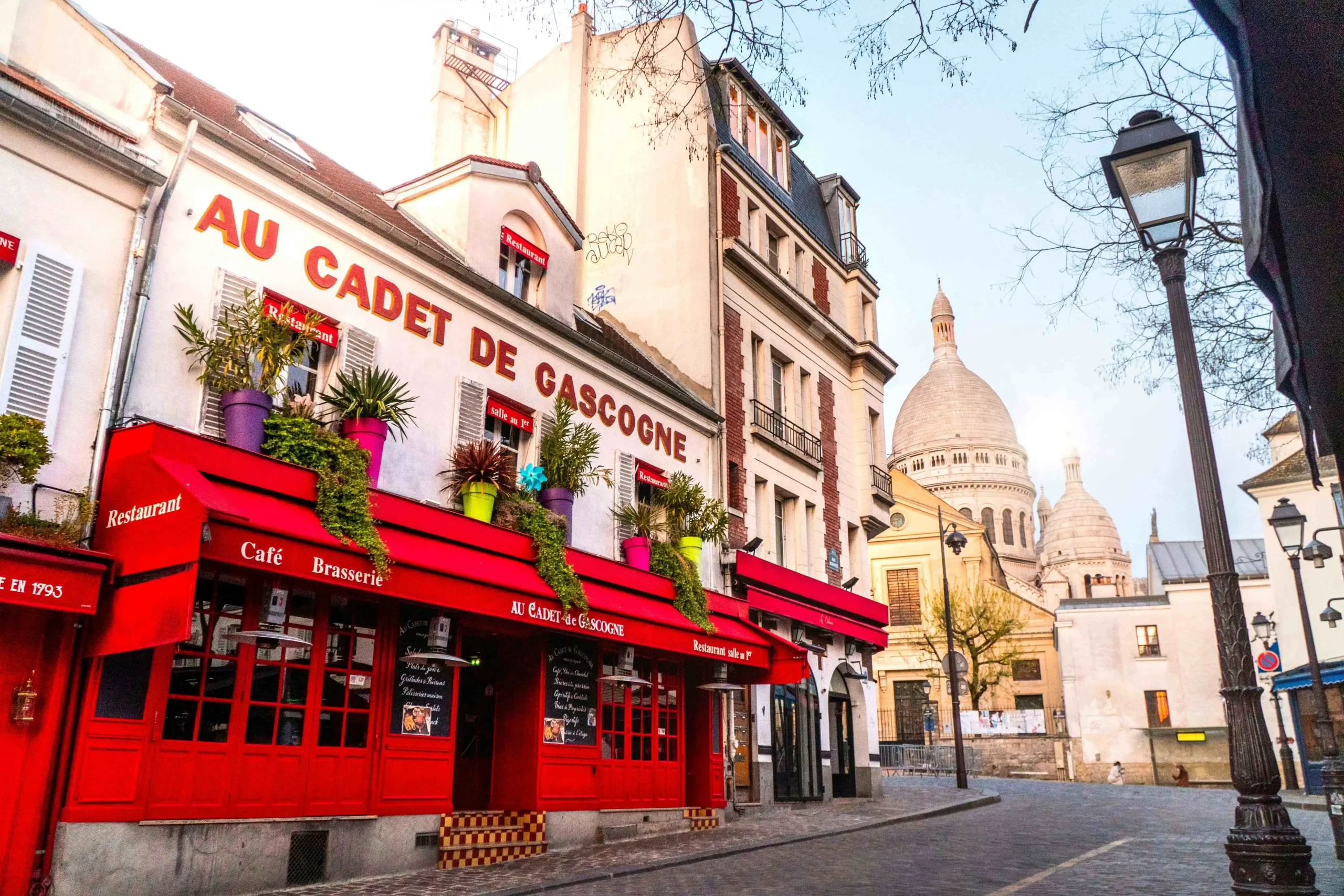 Ein Café mit roter Fassade und und Markise in Paris.