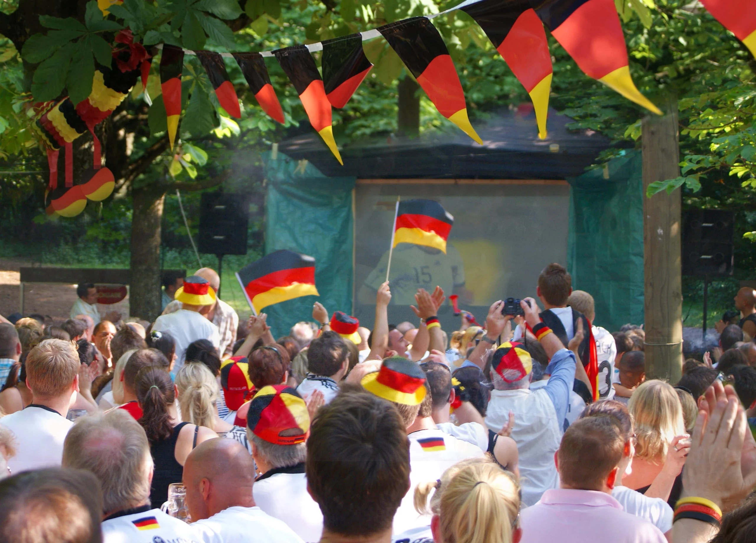 Deutschland-Fans beim Public-Viewing mit Deutschland-Fahnen, -Mützen und Girlanden