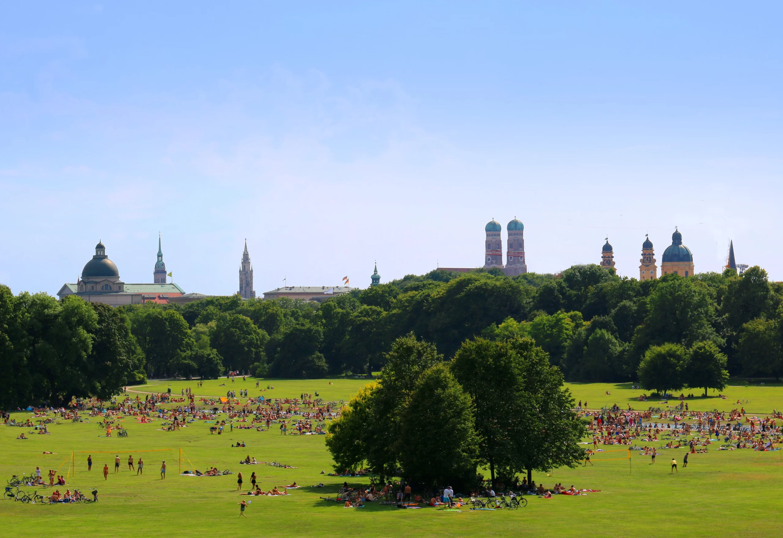 Englischer Garten in München in der warmen Jahreshälfte mit zahlreichen Menschen, die die Sonne genießen.