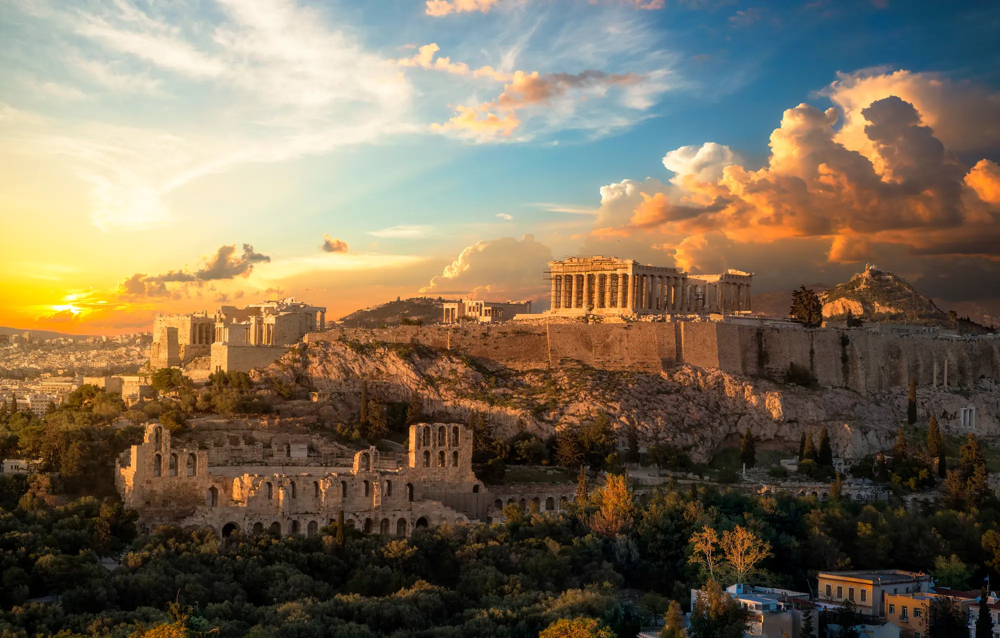 Panorama von Athen, der ersten Kulturhauptstadt Europas, bei Abenddämmerung, mit rot-orange-goldenen Akzenten, die die historischen Stätten und die lebhafte Stadtlandschaft in warmes Licht tauchen.