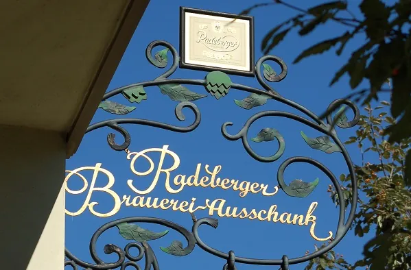 Goldenes Außenschild vor blauem Himmel vom Restaurant Radeberger Brauerei-Ausschank beim Kurzurlaub Sachsen