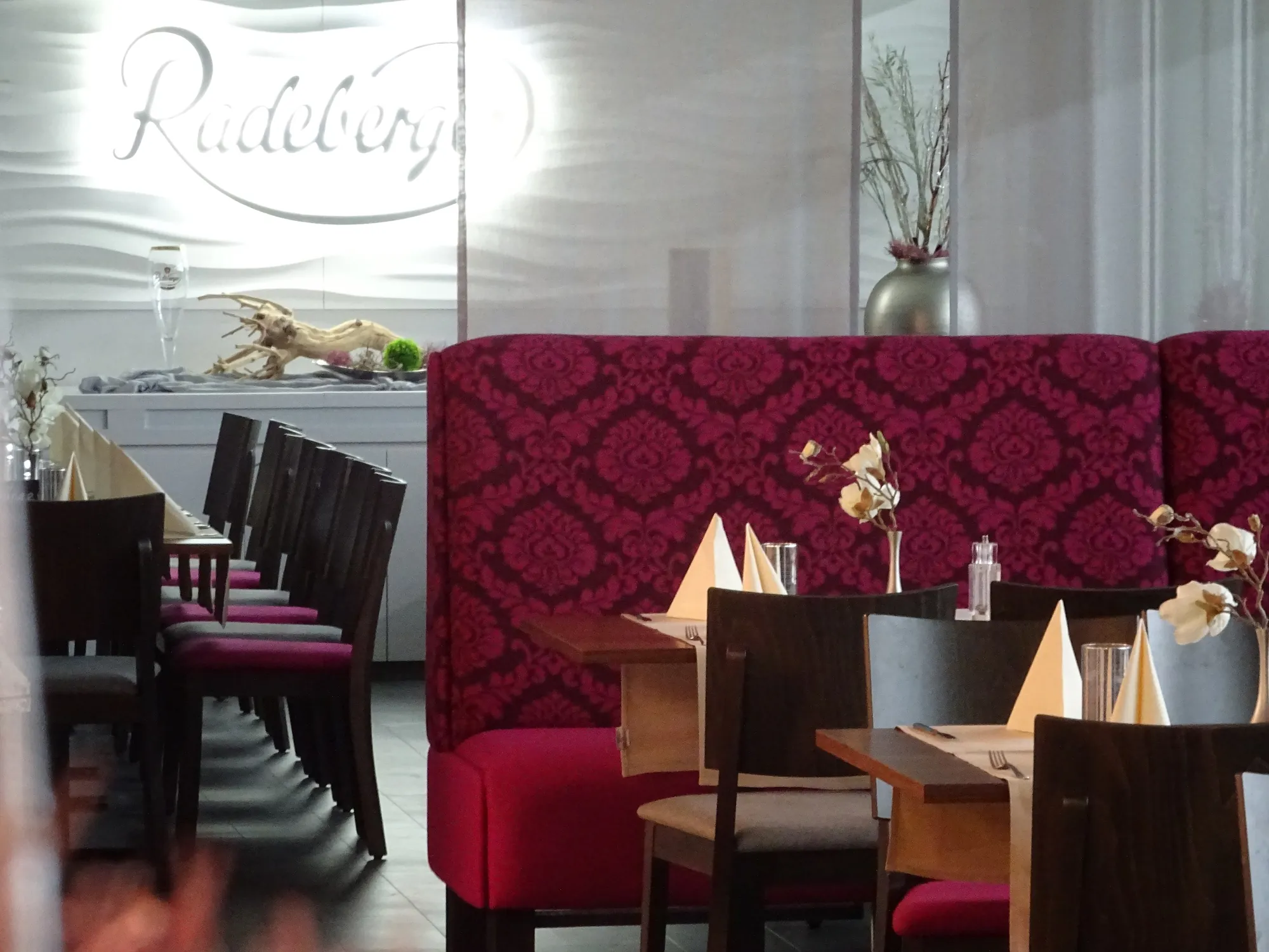 Gemütliche Sitzplätze im dezenten dunkelrot im Timmermanns Restaurant in der Sportwelt Radeberg beim Kurzurlaub Sachsen