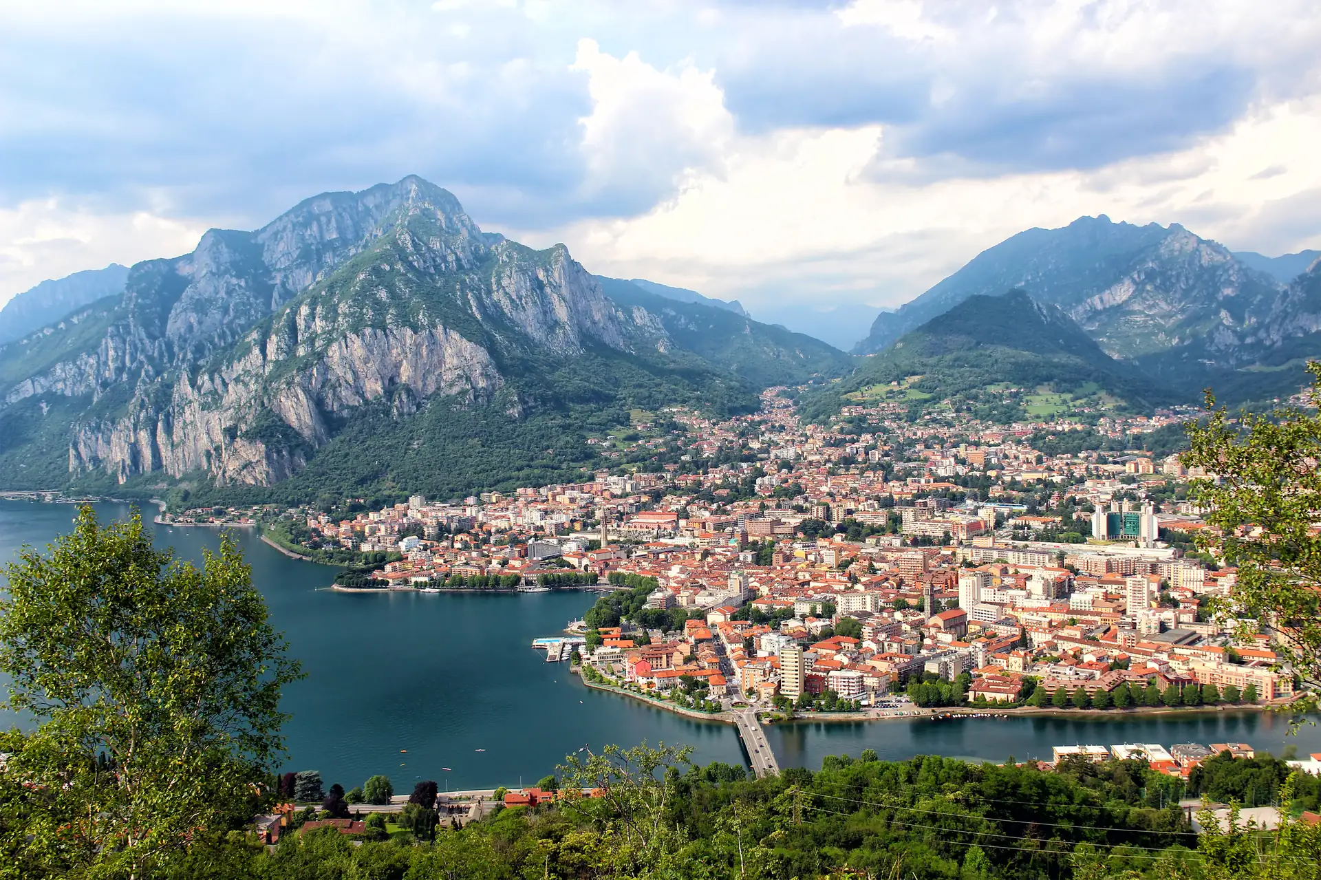 Blick auf Lecco am Comer See mit Bergen im Hintergrund und Stadt am Seeufer in der Lombardei