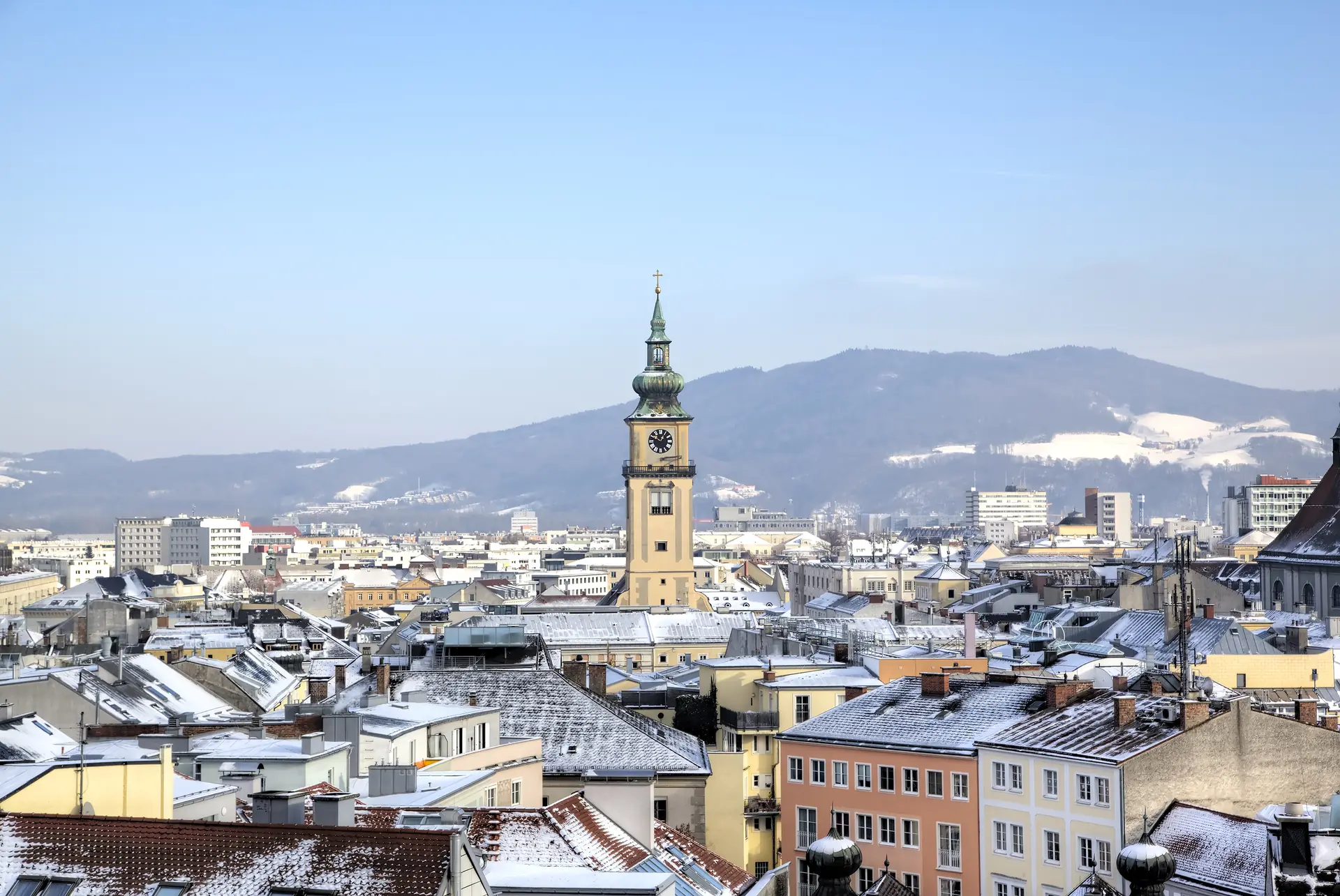 Stadtpanorama von Linz im Winter mit schneebedeckten Dächern