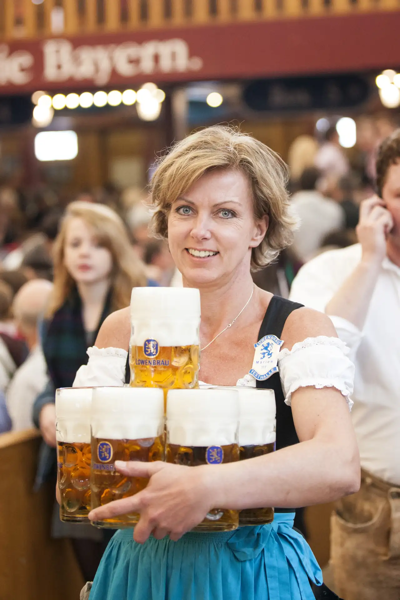 Kellnerin in Dirndl mit mehreren Maß Bier im Löwenbräu Zelt.