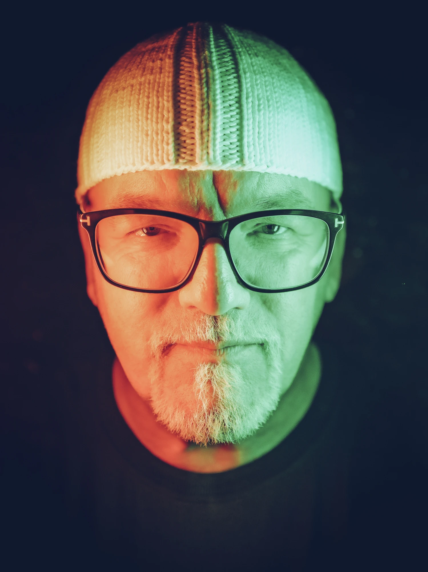 Mountain Mania 2024 - DJ Ötzi Konzert - Porträt von DJ Ötzi mit Brille und weißer Mütze in rot grünem Licht