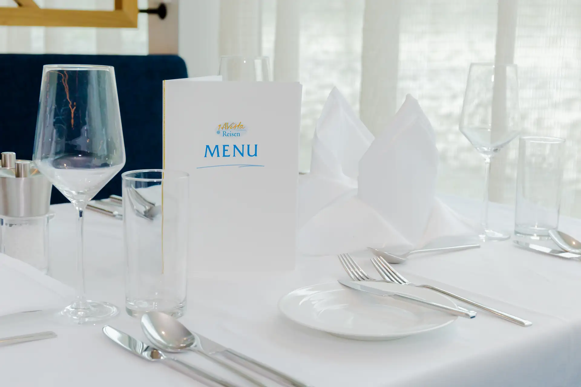 MS VistaSTAR: Weiß gedeckter Tisch mit Besteck, Gläsern und Menükarte mit der Aufschrift 'MENU'.