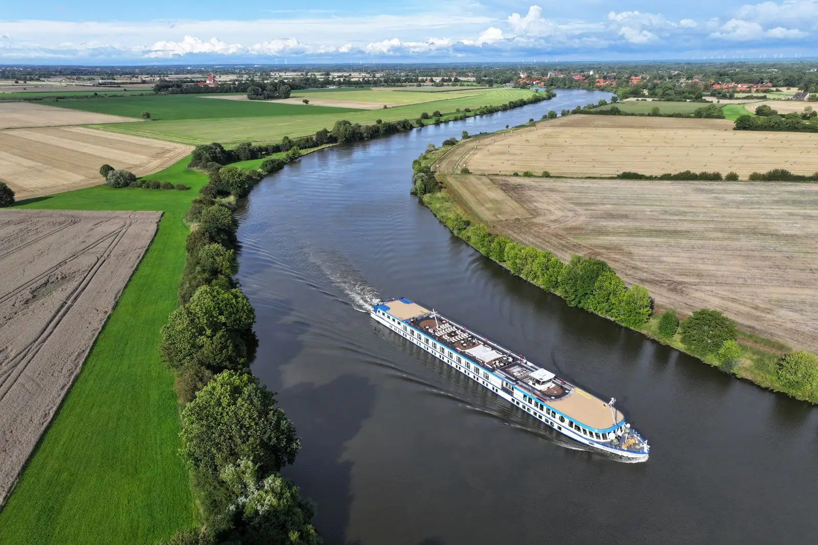 Panoramaansicht eines Kanals mit einem Schiff und einer grünen Landschaft.
