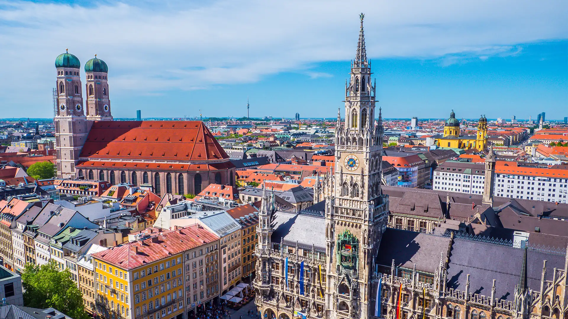 Panoramaaufnahme der Münchner Altstadt mit dem Neuen Rathaus im Vordergrund und der Frauenkirche mit ihren markanten Zwiebeltürmen im Hintergrund