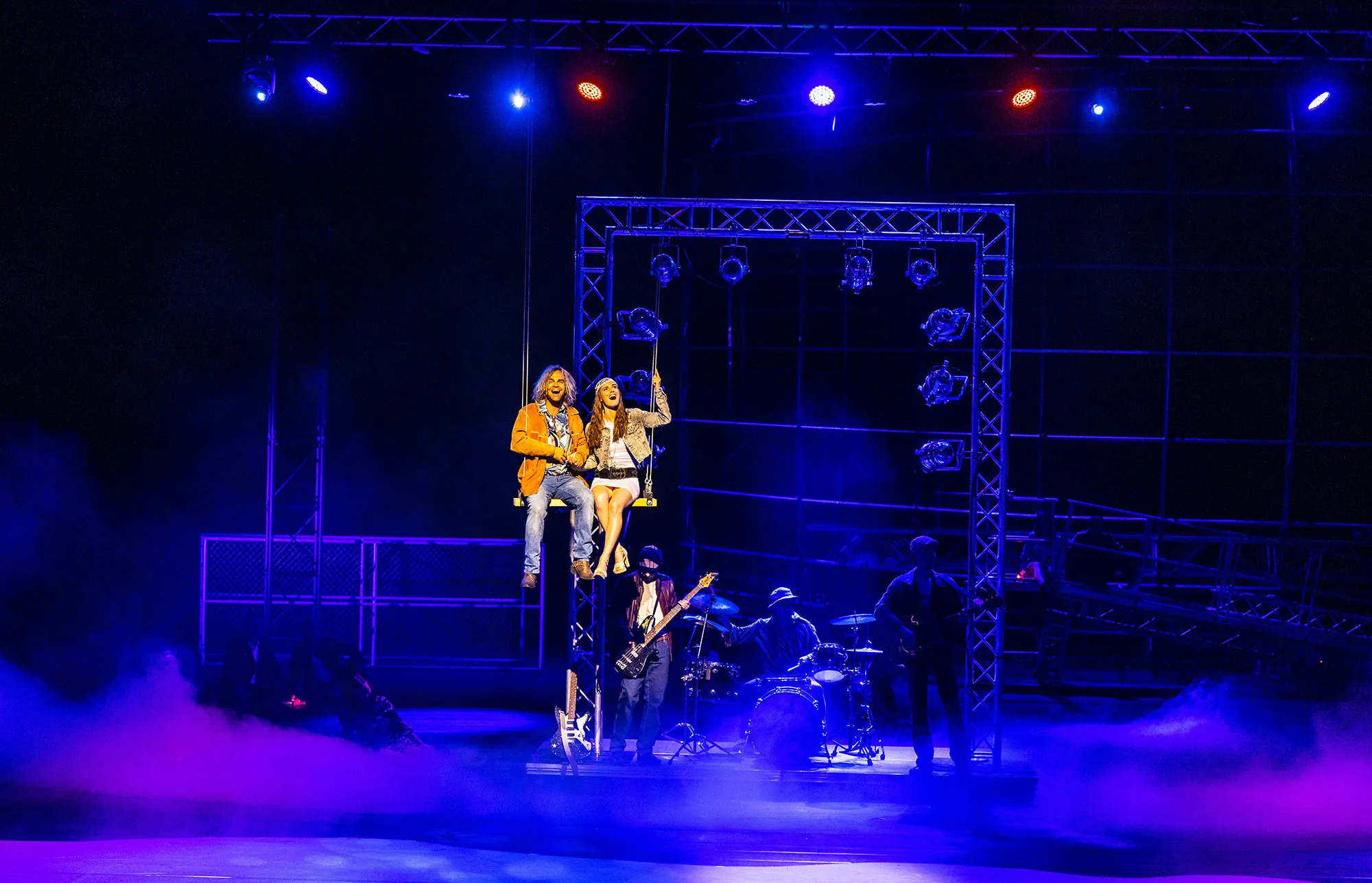 Bühnenansicht einer Musikshow mit Lichtern und Nebel.