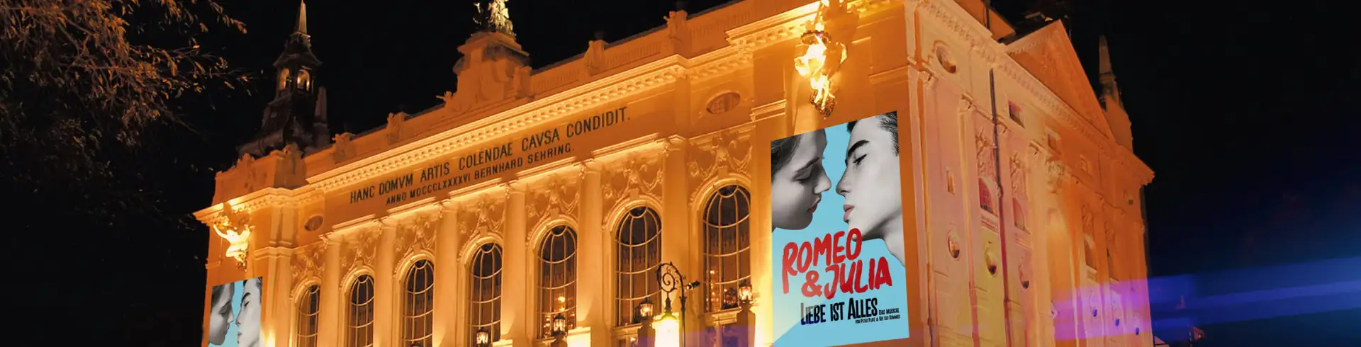 Musicalreisen nach Berlin im Bannerformat: Stage Theater des Westens am Abend beleuchtet mit Plakaten des Musicals Romeo & Julia