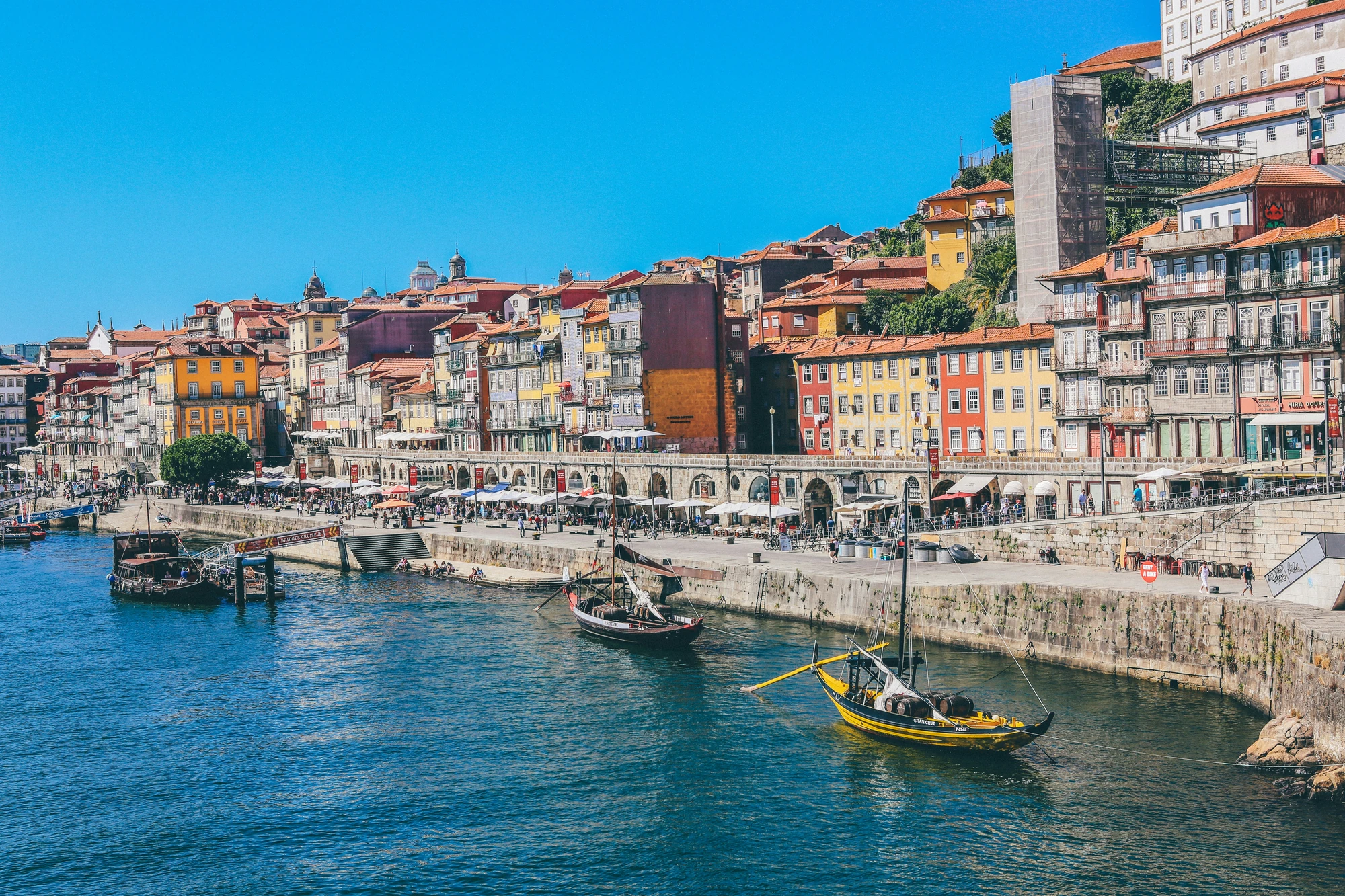 Malerische Stadtansicht von Porto mit bunten Häusern und Booten im Hafen.