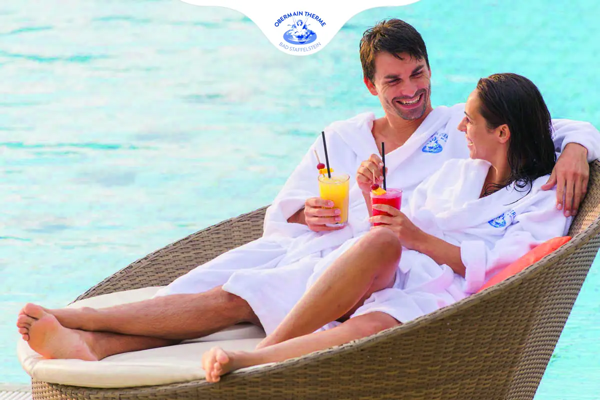 Paar relaxt im Sessel mit einem Cocktail gemeinsam am Pool in der Obermain Therme