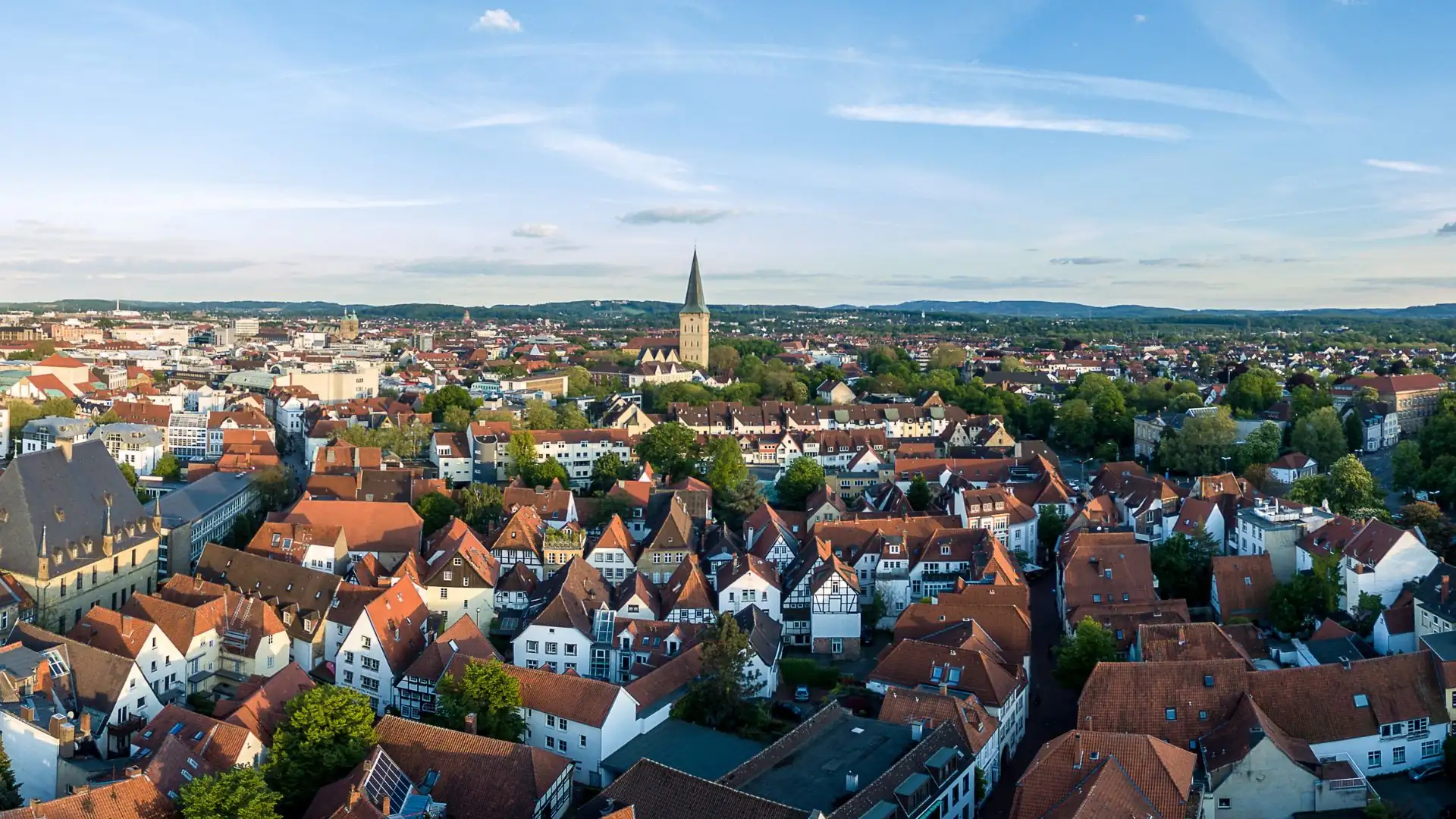Luftaufnahme einer Stadt mit historischen Gebäuden und einem Kirchturm.