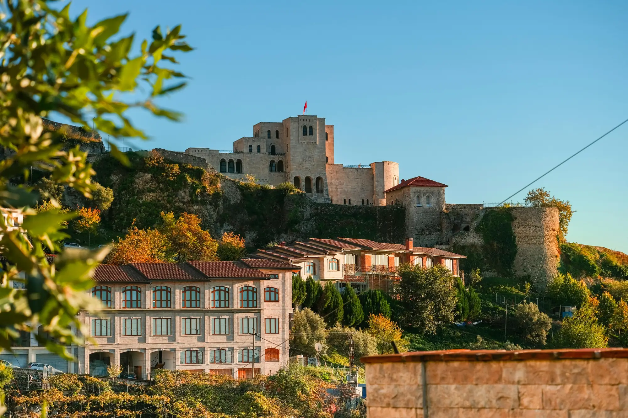 Burg und Häuser in Albanien mit Sonne.