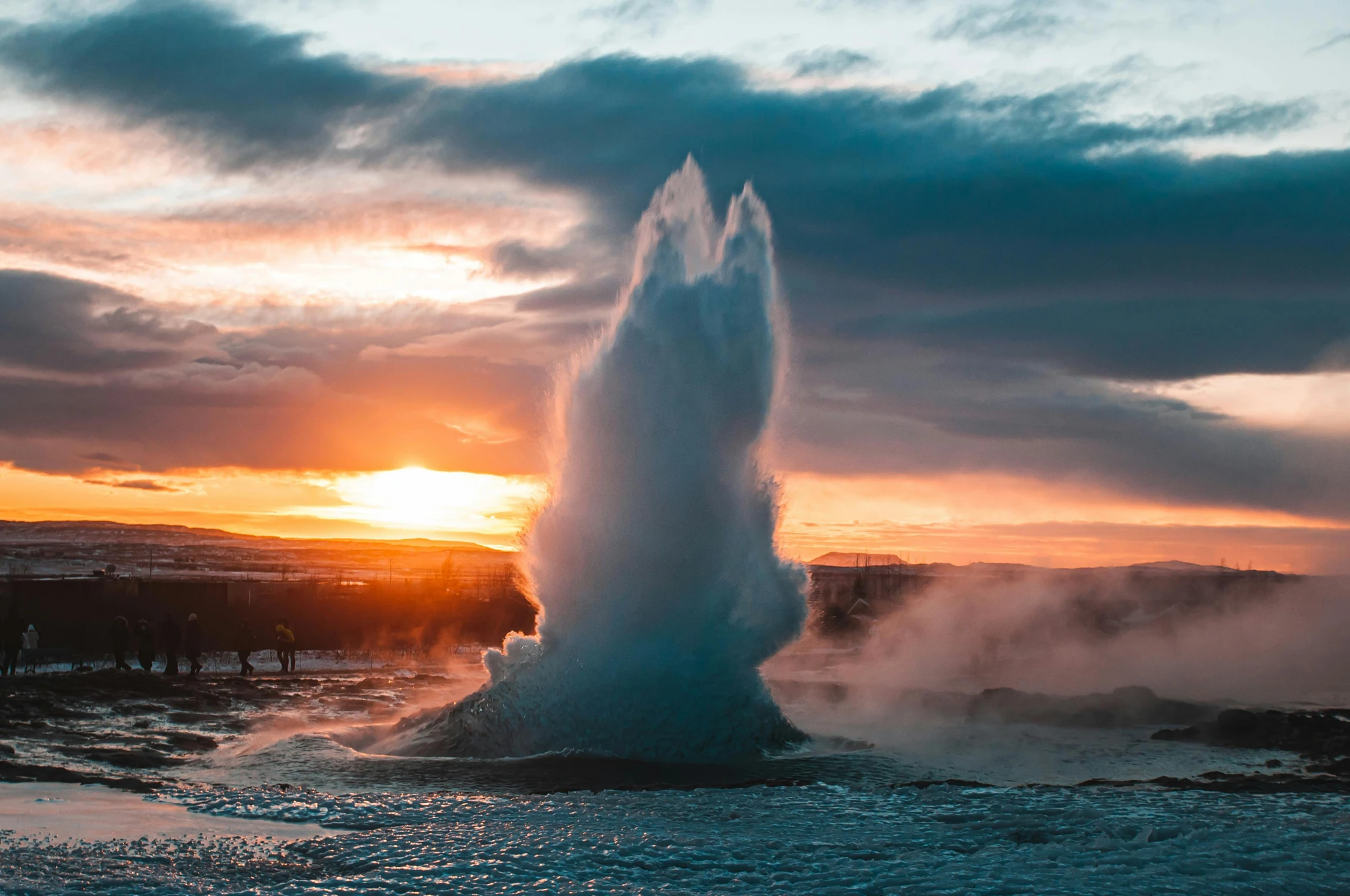 Ein Geysir in Island, der während des Sonnenuntergangs ausbricht.