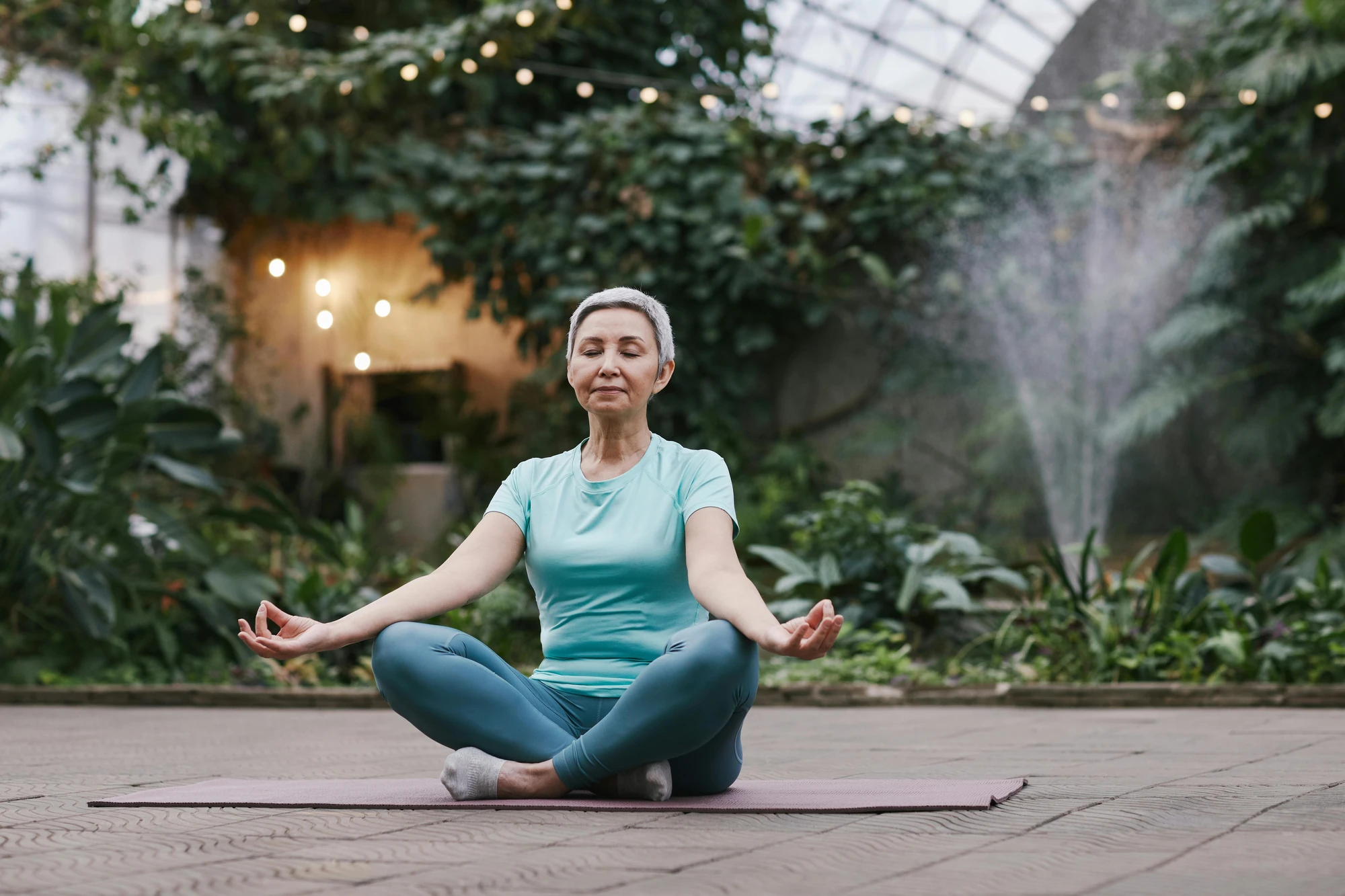 Yoga Pose, Frau mit kurzen Haaren, Garten im Hintergrund bei Wellness Urlaub
