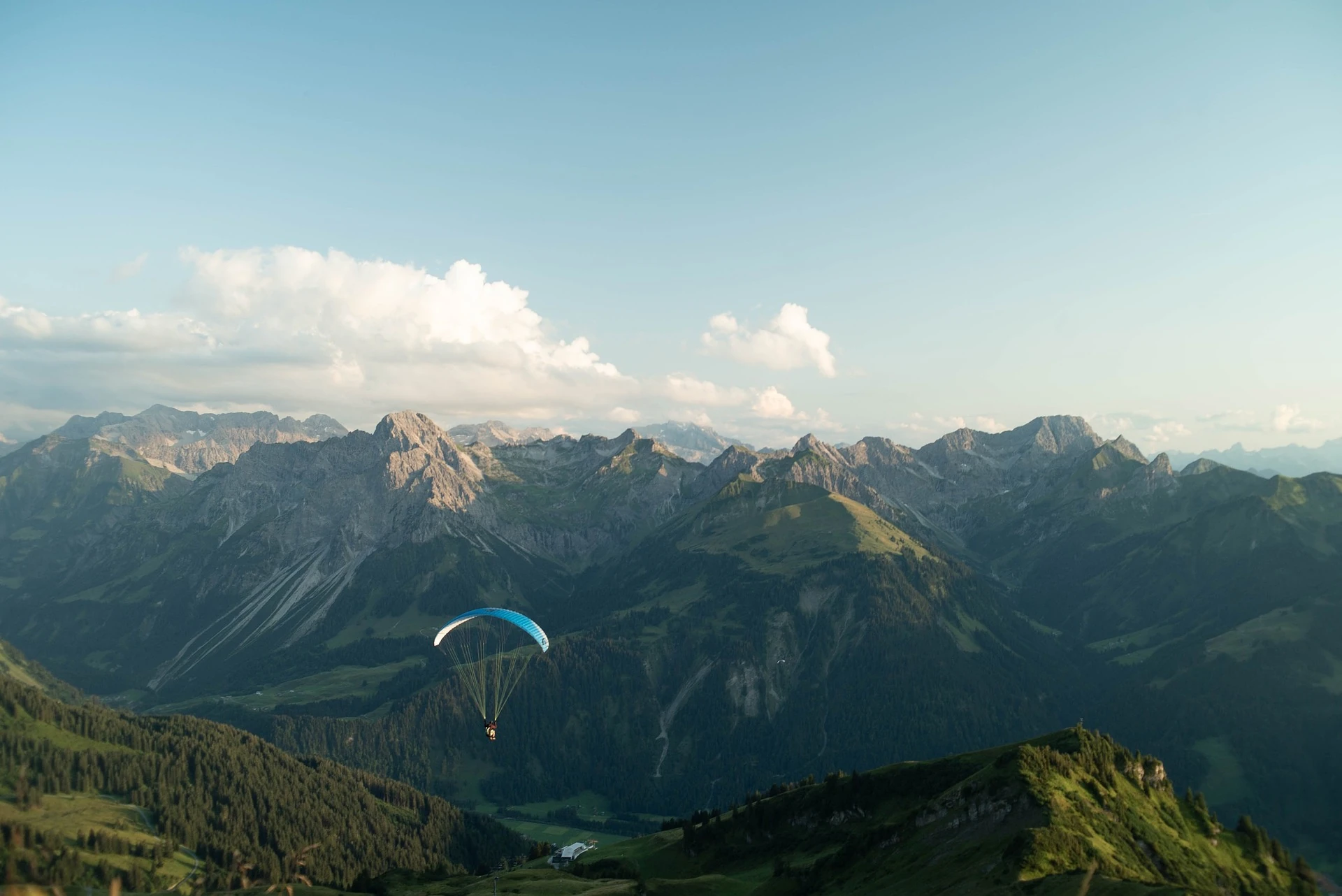 Paragliden in Österreich - Himmel mit Wolken, beeindruckende Berge im Hintergrund