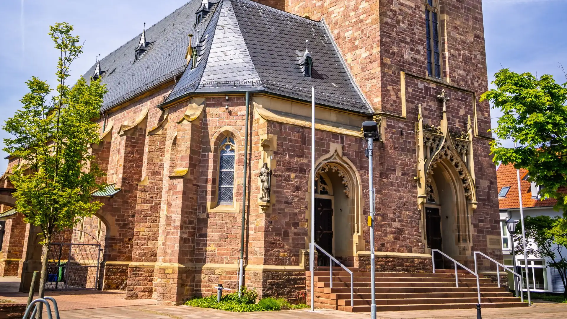 Ansicht einer historischen Kirche mit Steinfassade und Türmchen.