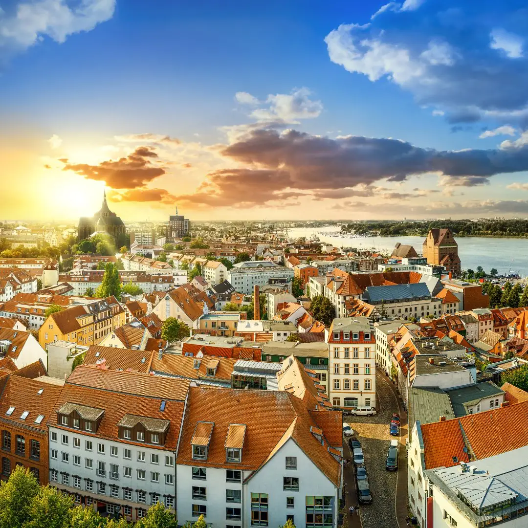 Panoramaansicht einer Stadt bei Sonnenuntergang mit roten Dächern