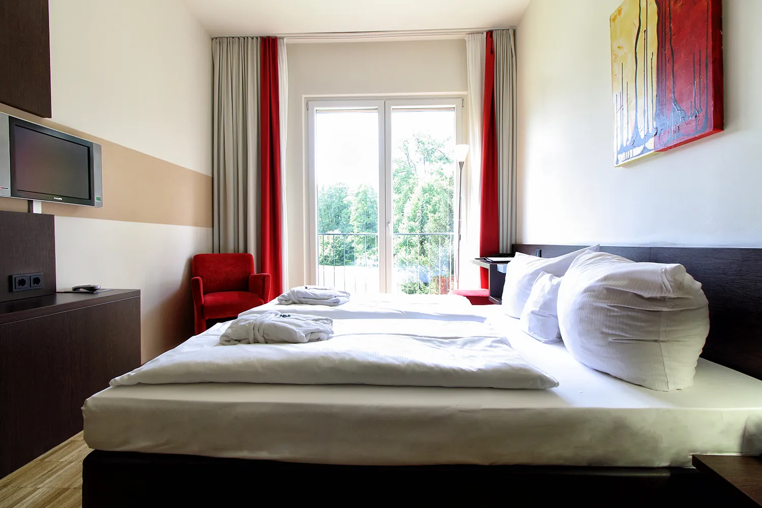 Beispiel für ein Zimmer im Santé Royale Bad Brambach mit Doppelbett und Balkonfenster