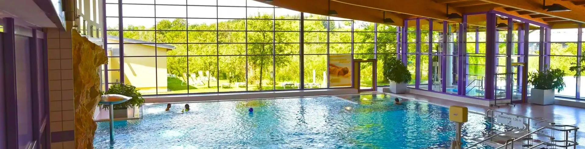 Abbildung des Santé Royale Wolkenstein Poolbereich mit bequemer Einstiegstreppe in den Warmbad Innenpool und Zugang zum Außenbecken