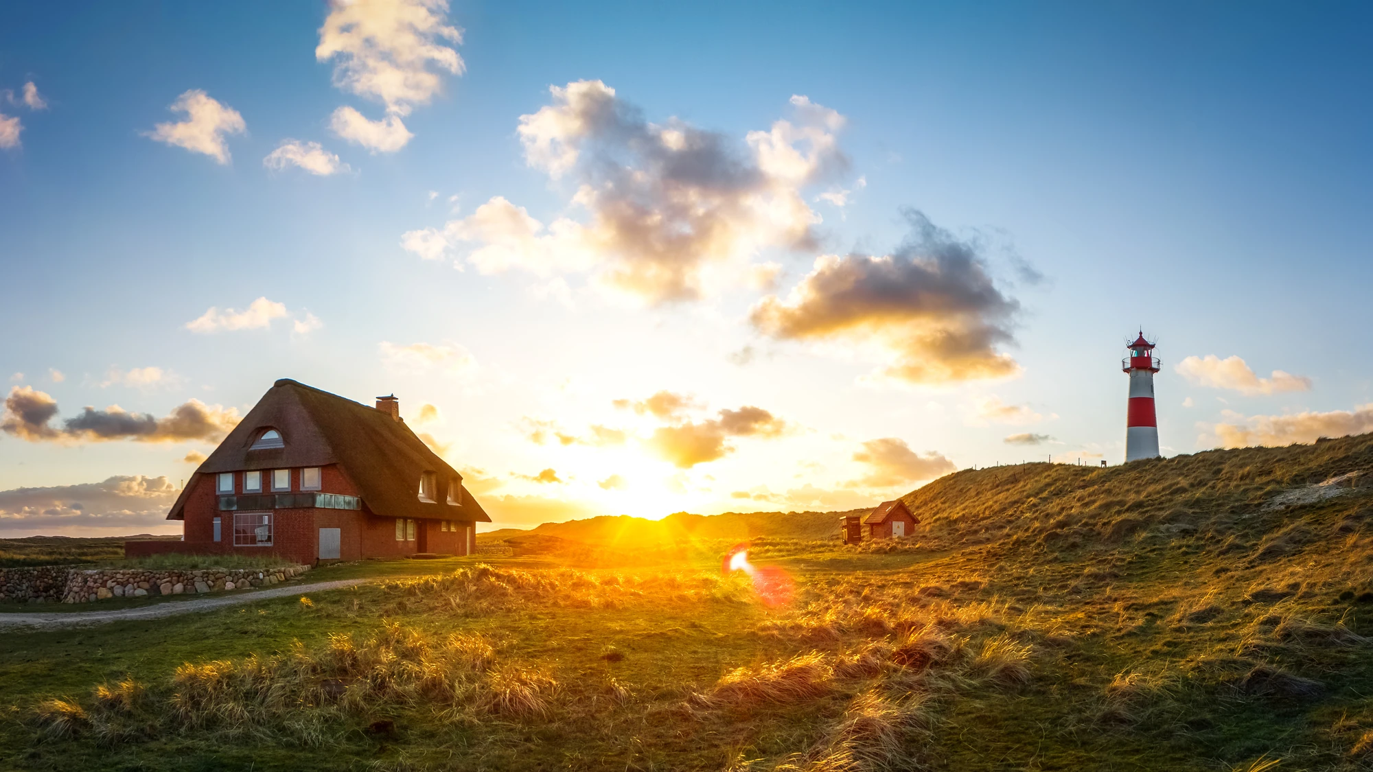 Schönste Strände Nordsee: Haus und Leuchtturm in den Dünen des Lister Ellenbogen auf Sylt