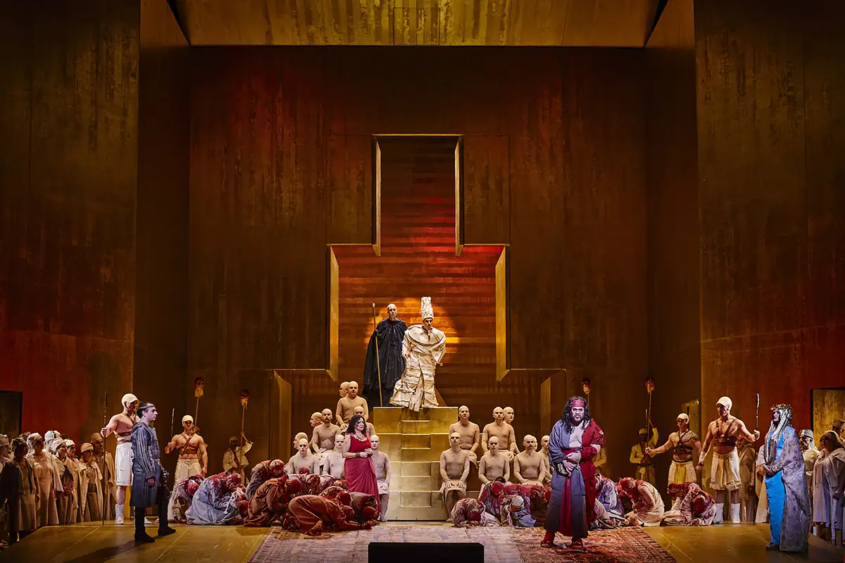 Aida in der Semperoper Dresden: Szene mit vielen Darstellern vor einem großen, goldfarbenen Thron auf einer Bühne mit warmem Licht.