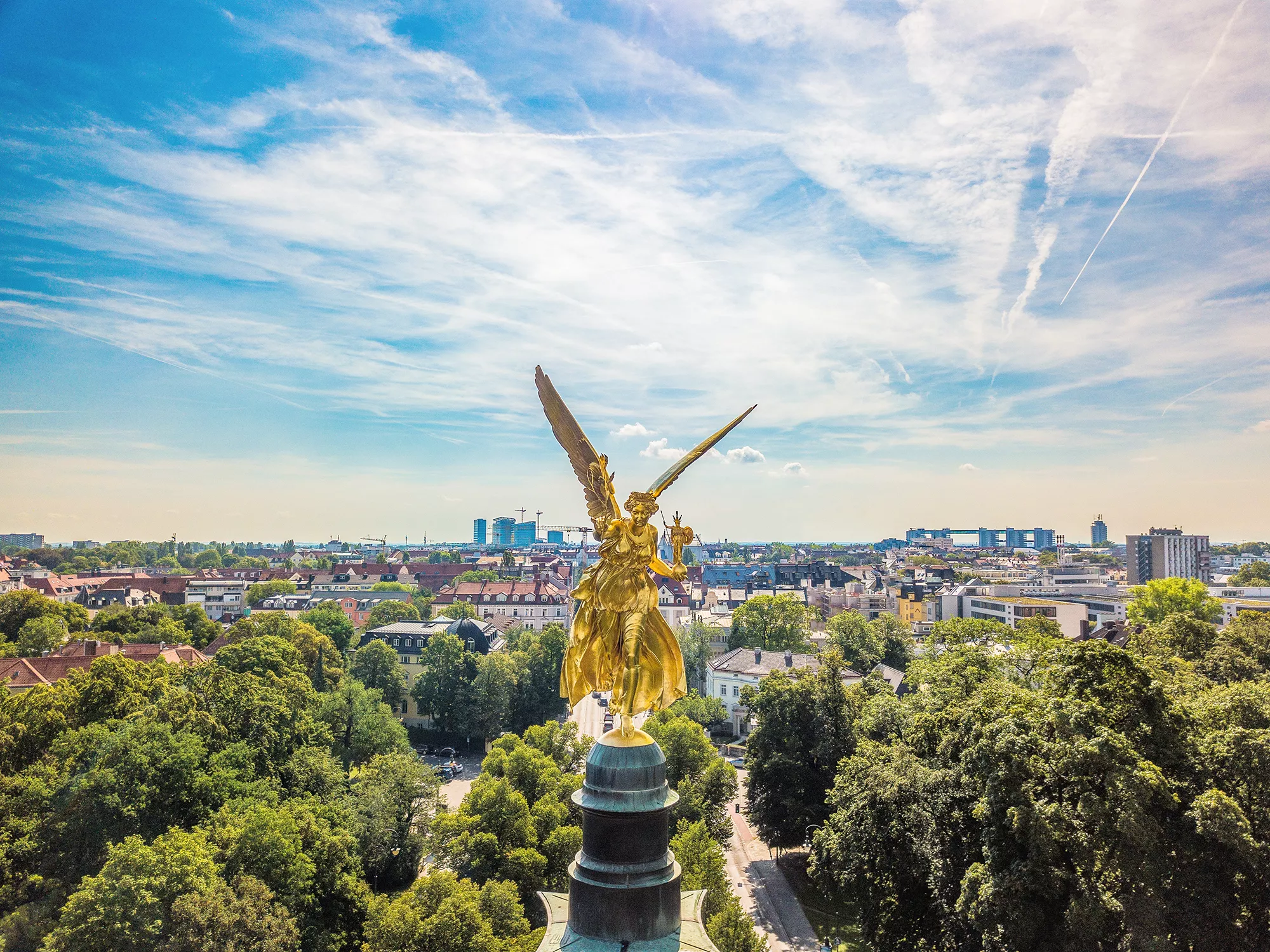 Blick auf den goldenen Friedensengel mit der Stadt München im Hintergrund