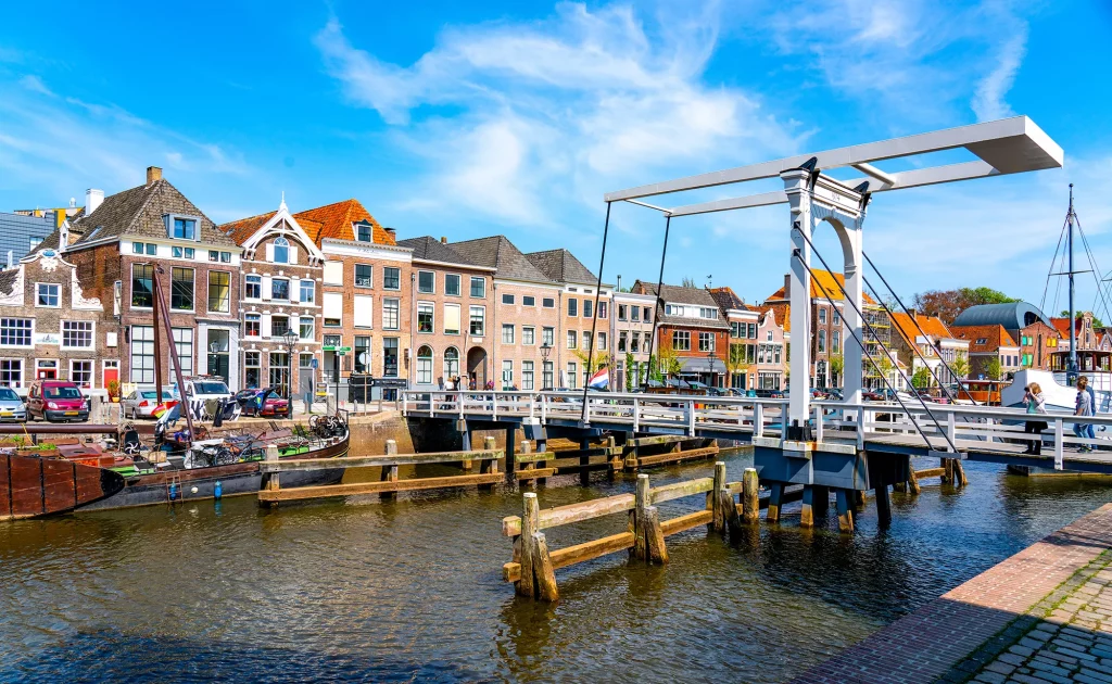 Blick auf eine geschlossene Klappbrücke die einen Kanal in der Stadt Zwolle überspannt mit Uferpromenade und einer bunten Häuserfront