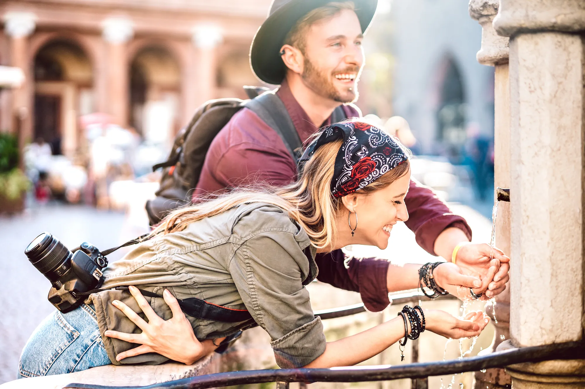 Städtereise: Paar macht beim Sightseeing Pause am Brunnen