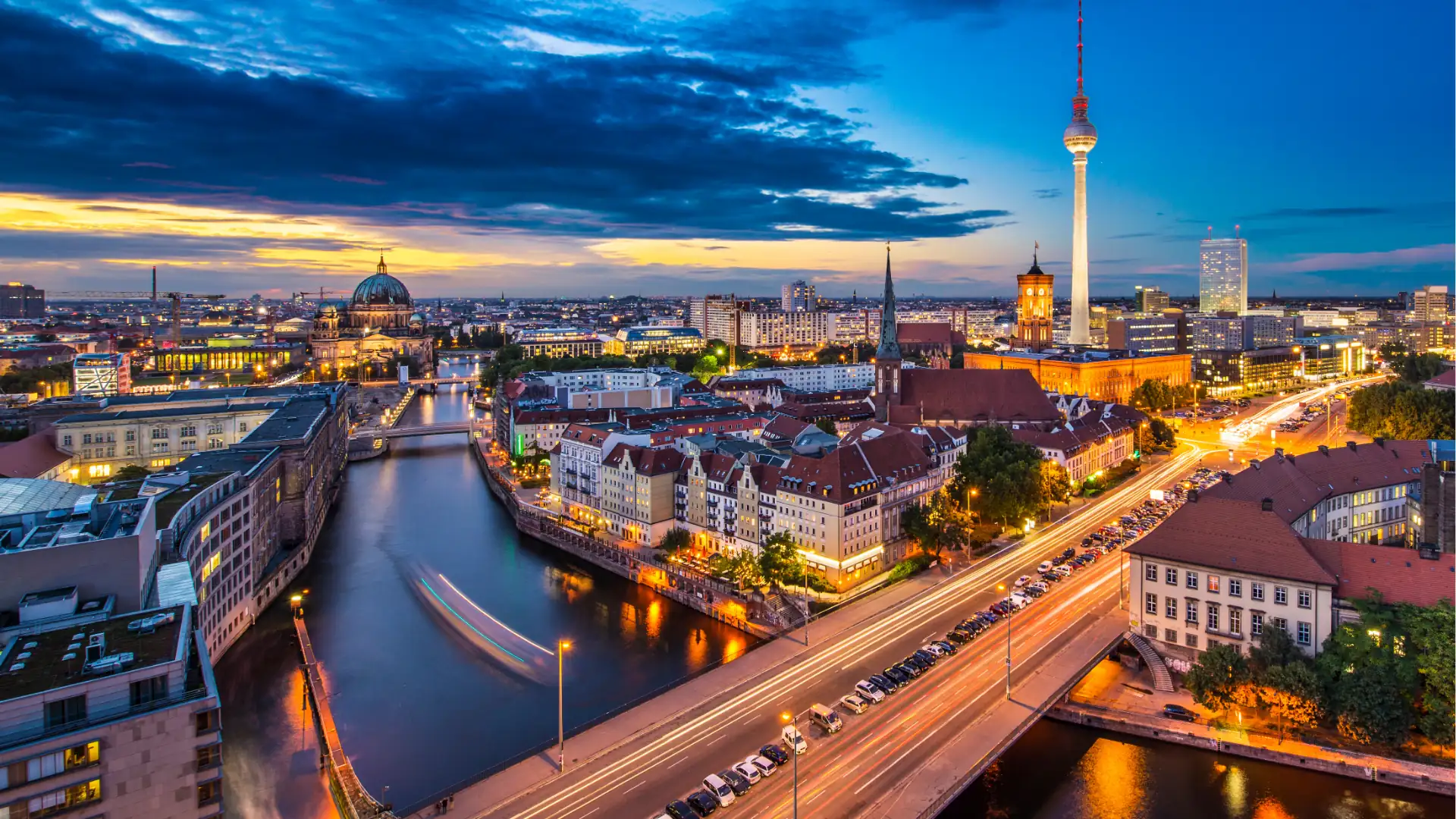Städtereisen Metropolen Symbolbild: Stadtpanorama von Berlin mit Berliner Dom, Spree und Fernsehturm am Abend.