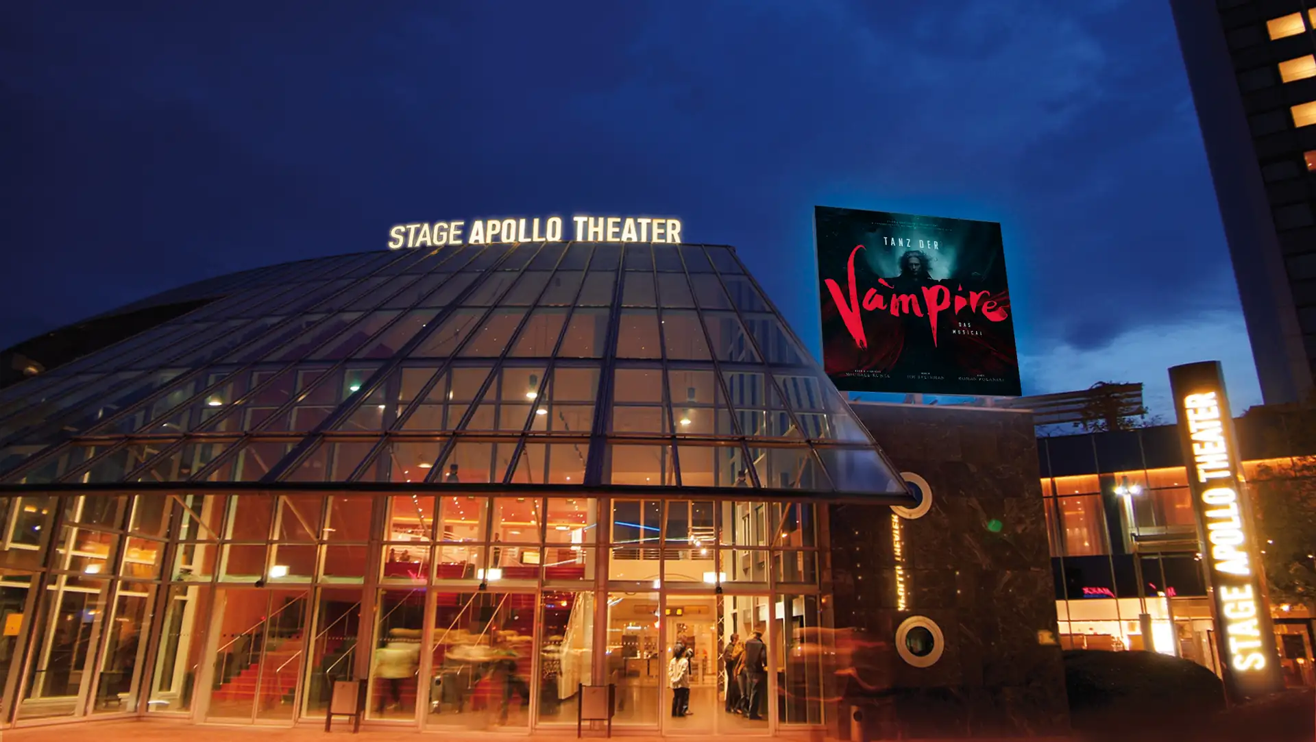 Das beleuchtete Stage Apollo Theater bei Nacht mit einem großen Werbeplakat für das Musical »Tanz der Vampire«