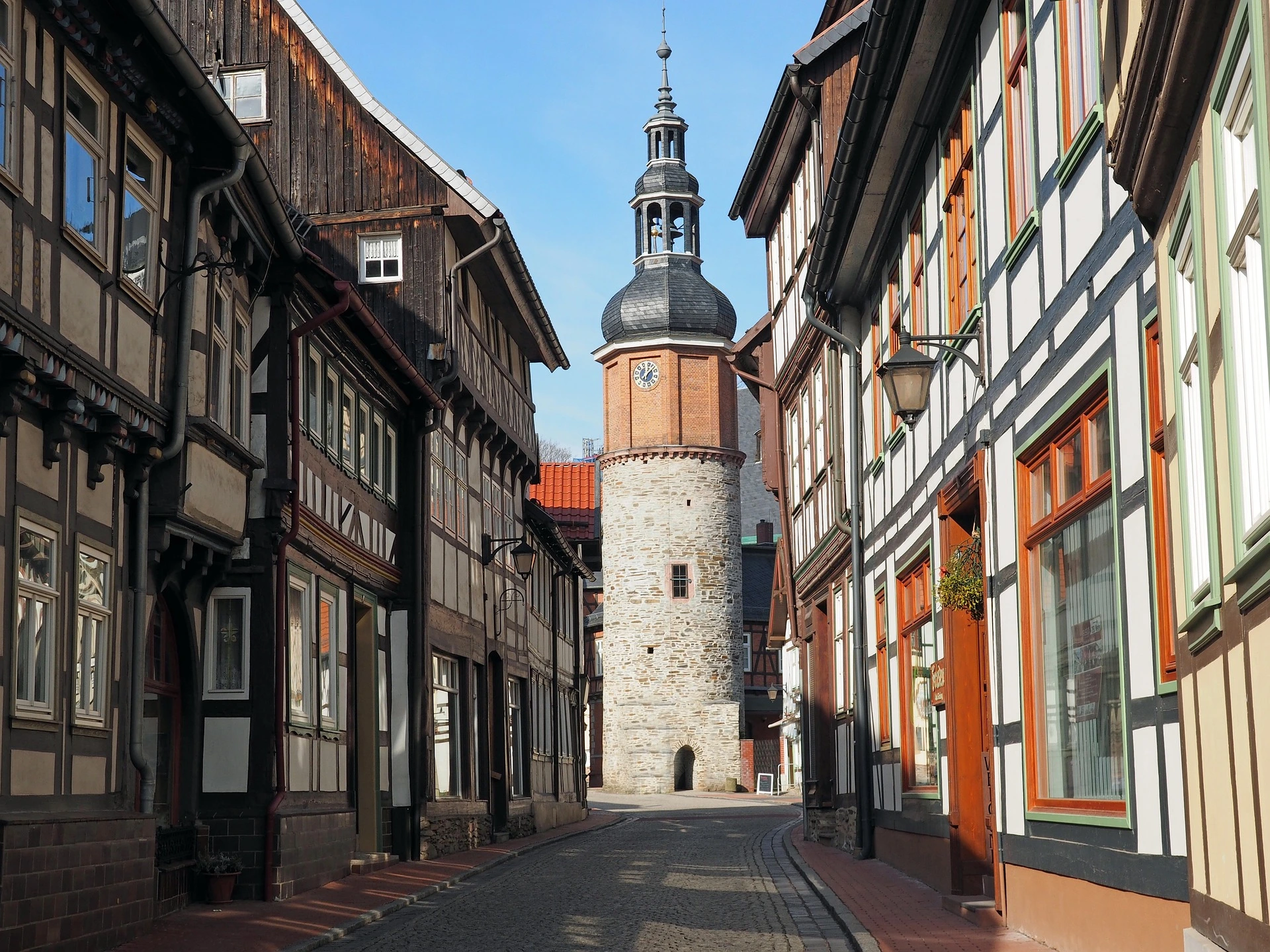 Kirchturm von Stolberg im Harz sowie Fachwerkhäuser.