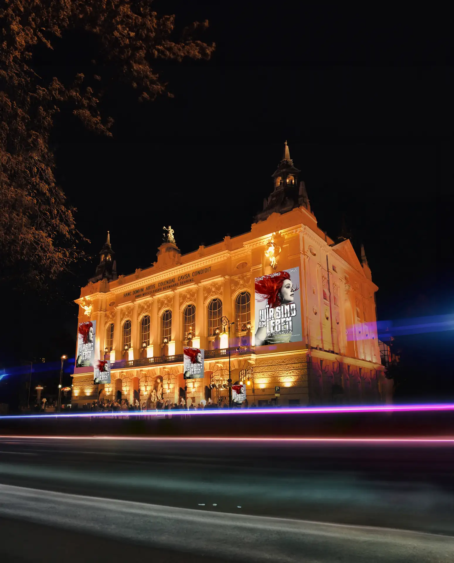Beleuchtetes Gebäude des Theater des Westens in Berlin bei Nacht mit Bannern für das Musical 'Wir sind am Leben'