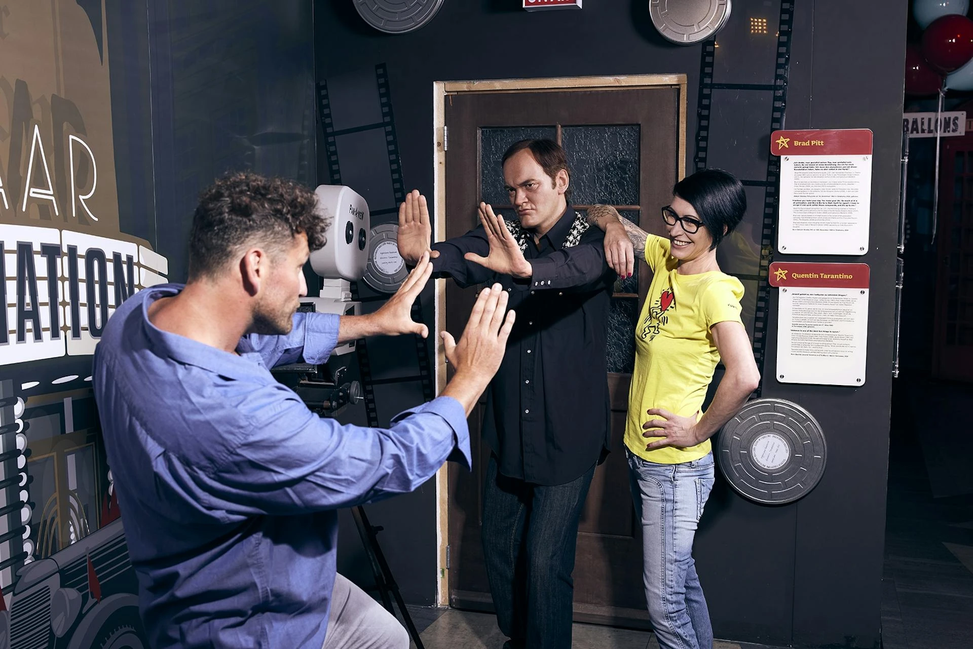 Madame Tussauds Wien - Besucher*innen posieren neben Regisseur Quentin Tarantino