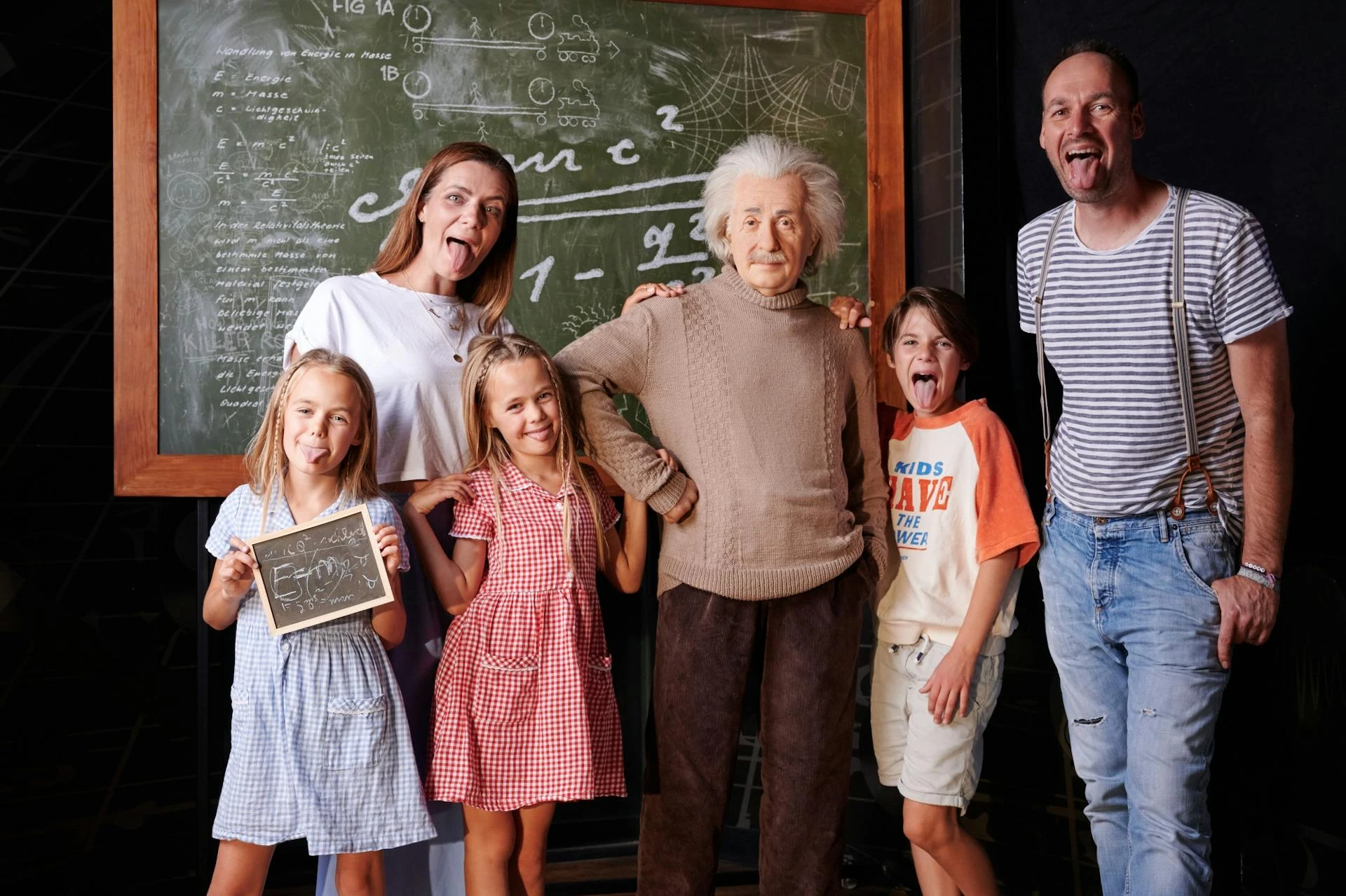 Madame Tussauds Berlin - Familie grinsend neben Albert Einstein und einer beschmierten Tafel